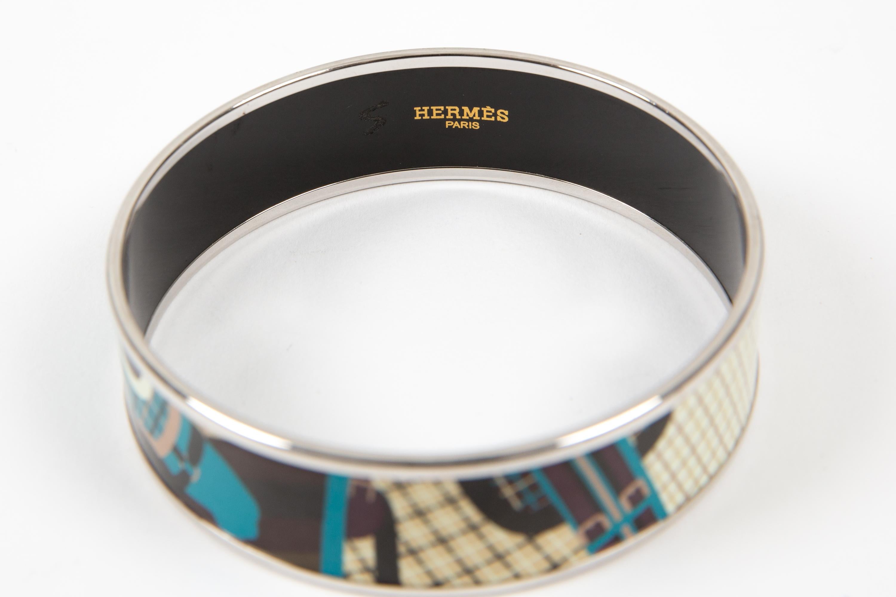 Bracelet large en émail bleu Hermès, avec quincaillerie argentée, motifs de chevaux fantaisie, logo intérieur piqué.  
Taille : M  
Fabriqué en France, piqué Hermès 
Circa 2000s 
Diamètre : 2,7 pouces (7 cm)
Largeur : 2 cm (0,8 po) 
En bon état
