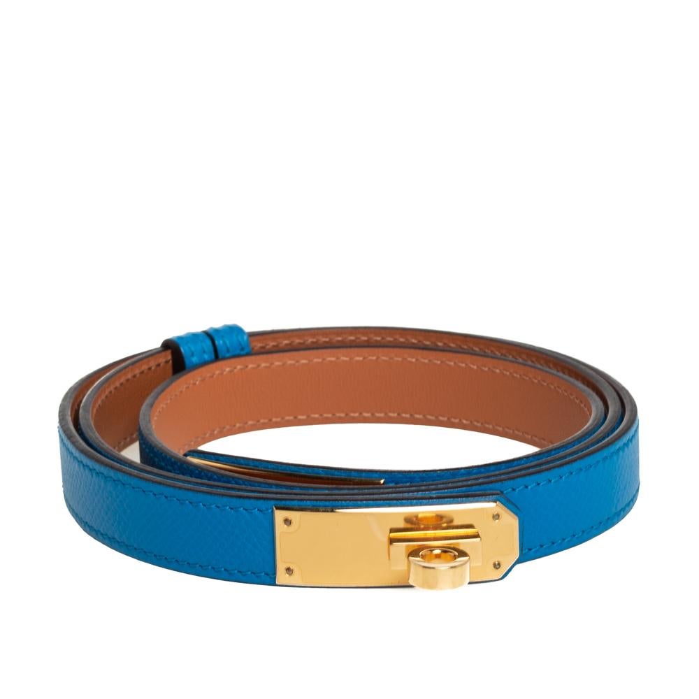 Complete any ensemble with a touch of luxurious fashion by flaunting this beauty of a belt from Hermes. It is crafted from blue-hued Epsom leather and detailed with the signature Kelly lock in gold-tone metal. The belt will look great with high