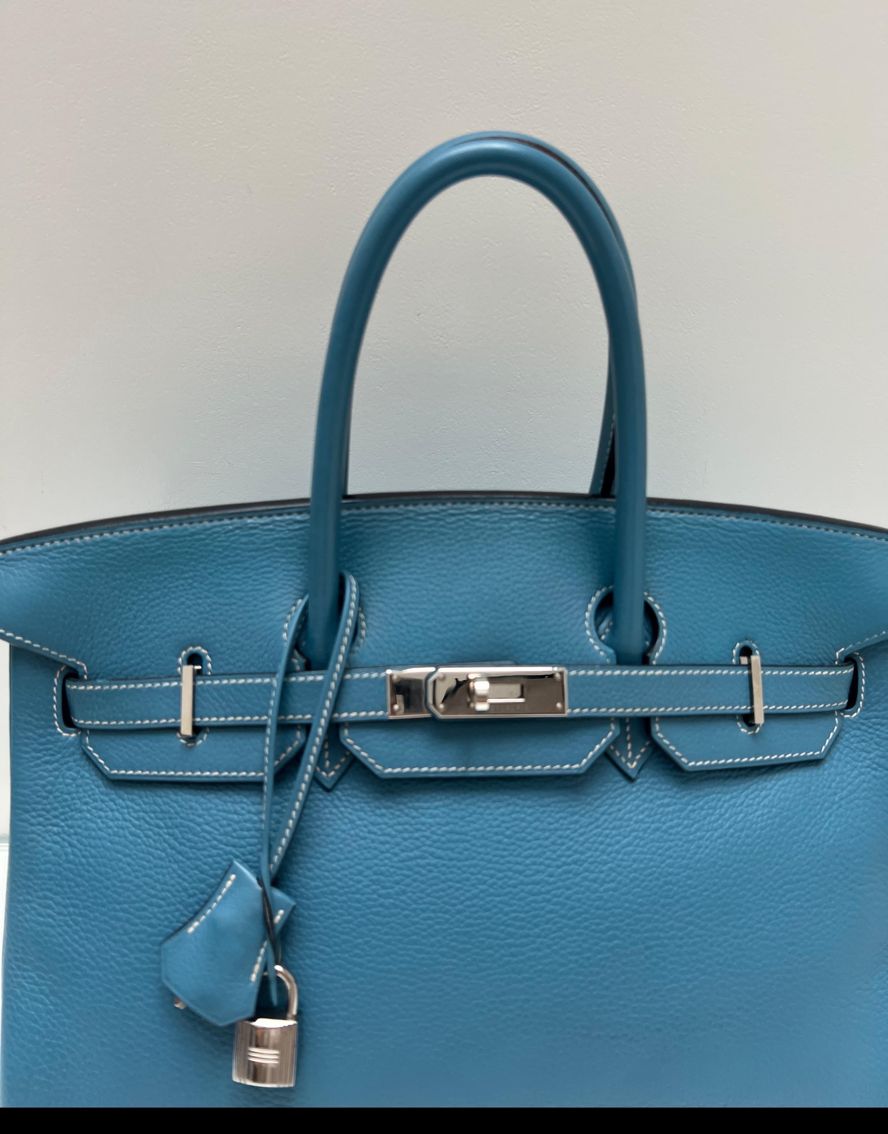 Sac Hermes Jean Birkin 35 bleu. Couleur bleue emblématique. Quincaillerie en argent palladium. Excellent état. Coutures blanches contrastées. Intérieur propre. Comprend une clochette, un cadenas, des clés et un sac à poussière. Un bon