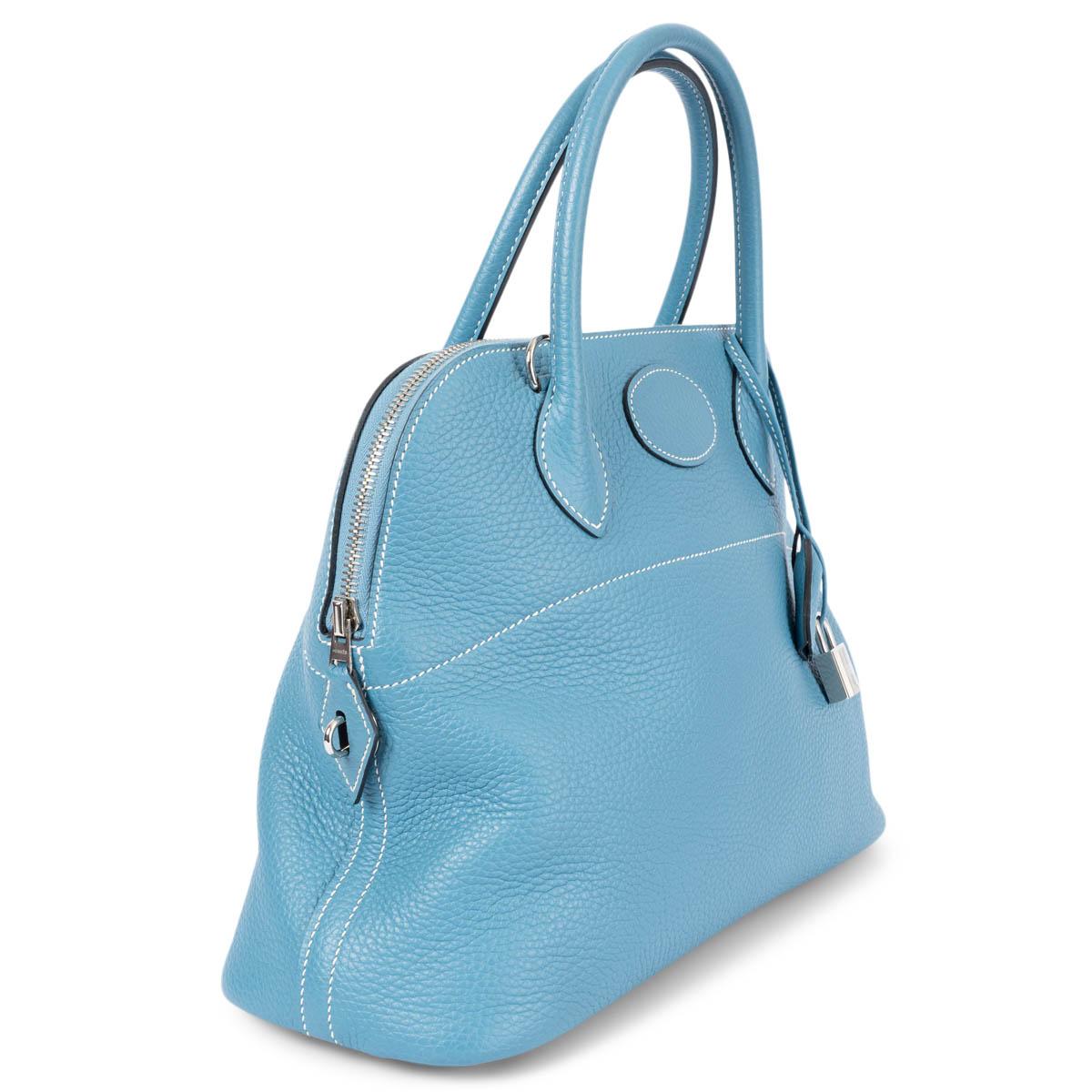 100% authentic Hermes 'Bolide 31' bag in Bleu Jean (light blue) Taurillon Clemence leather with contrasting white stitching and palladium-plated hardware. Opens with a zipper on top. Lined in Bleu Jean lamb skin leather with an open pocket against