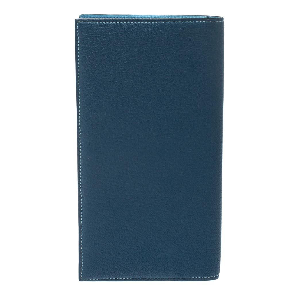 This stylish and functional Evelyne long wallet comes from the iconic house of Hermes. Crafted meticulously in France, it is made from quality leather and comes in a lovely shade of blue. It has a perforated H on the exterior and an open fold