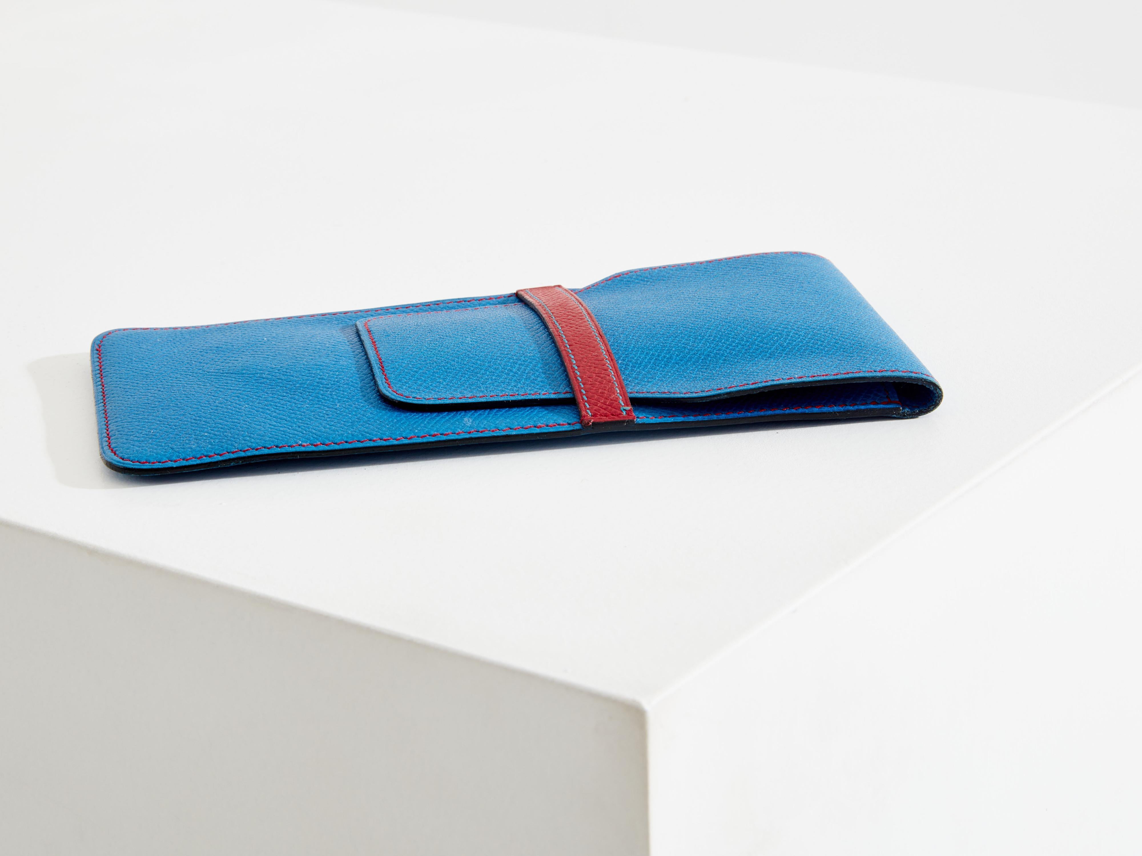 This blue Hermès pen case from the 1990s is an elegant and functional piece. Made from Epsom calfskin, a leather embossed through heat printing, it features a fine and regular grain that makes it more rigid. Lightweight and scratch-resistant, Epsom