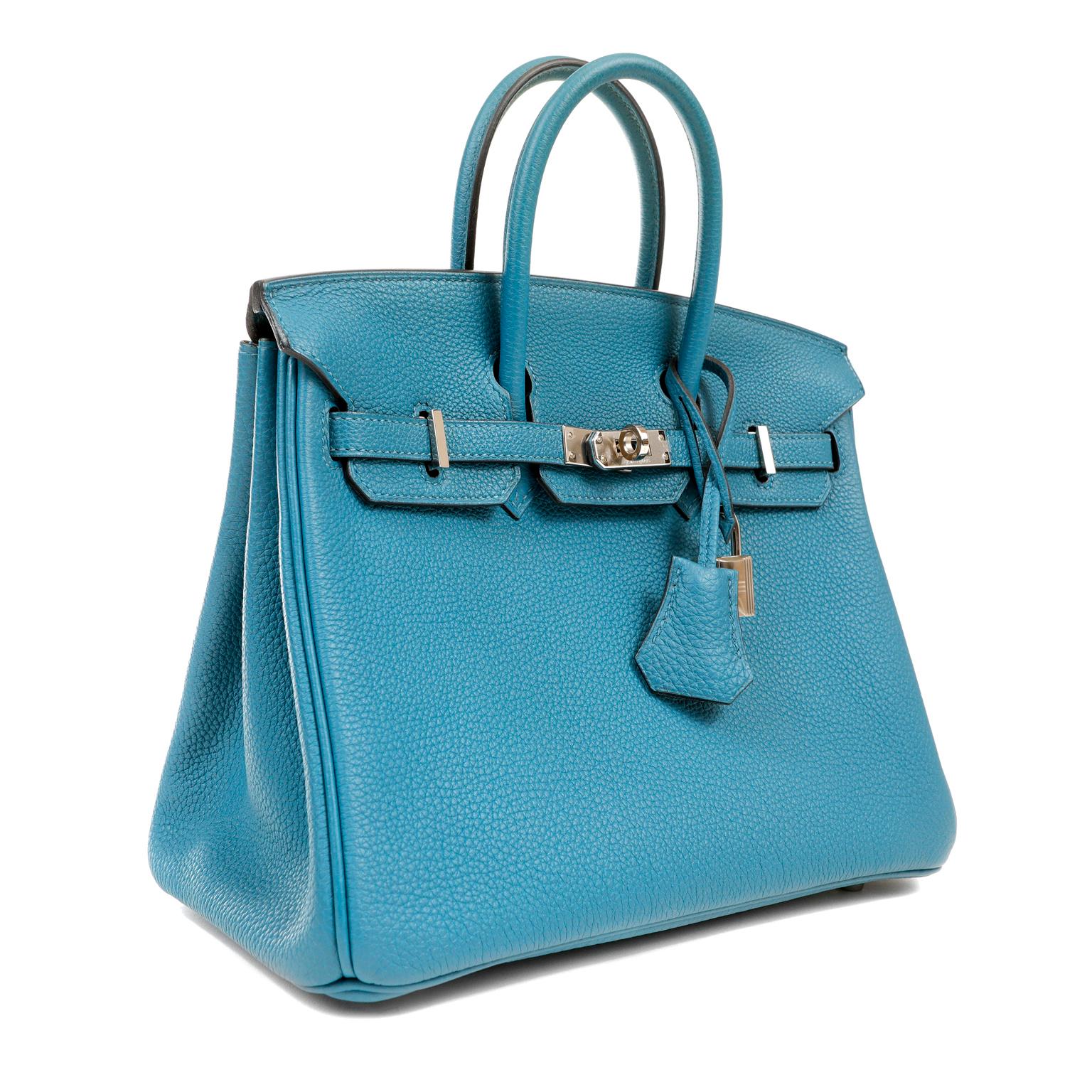 This authentic Hermès Blue Togo 25 cm Birkin Bag is in pristine unworn condition with the plastic intact on the hardware.  Waitlists exceeding a year are commonplace for the intensely coveted leather Birkin bag.  Each piece is hand sewn by skilled