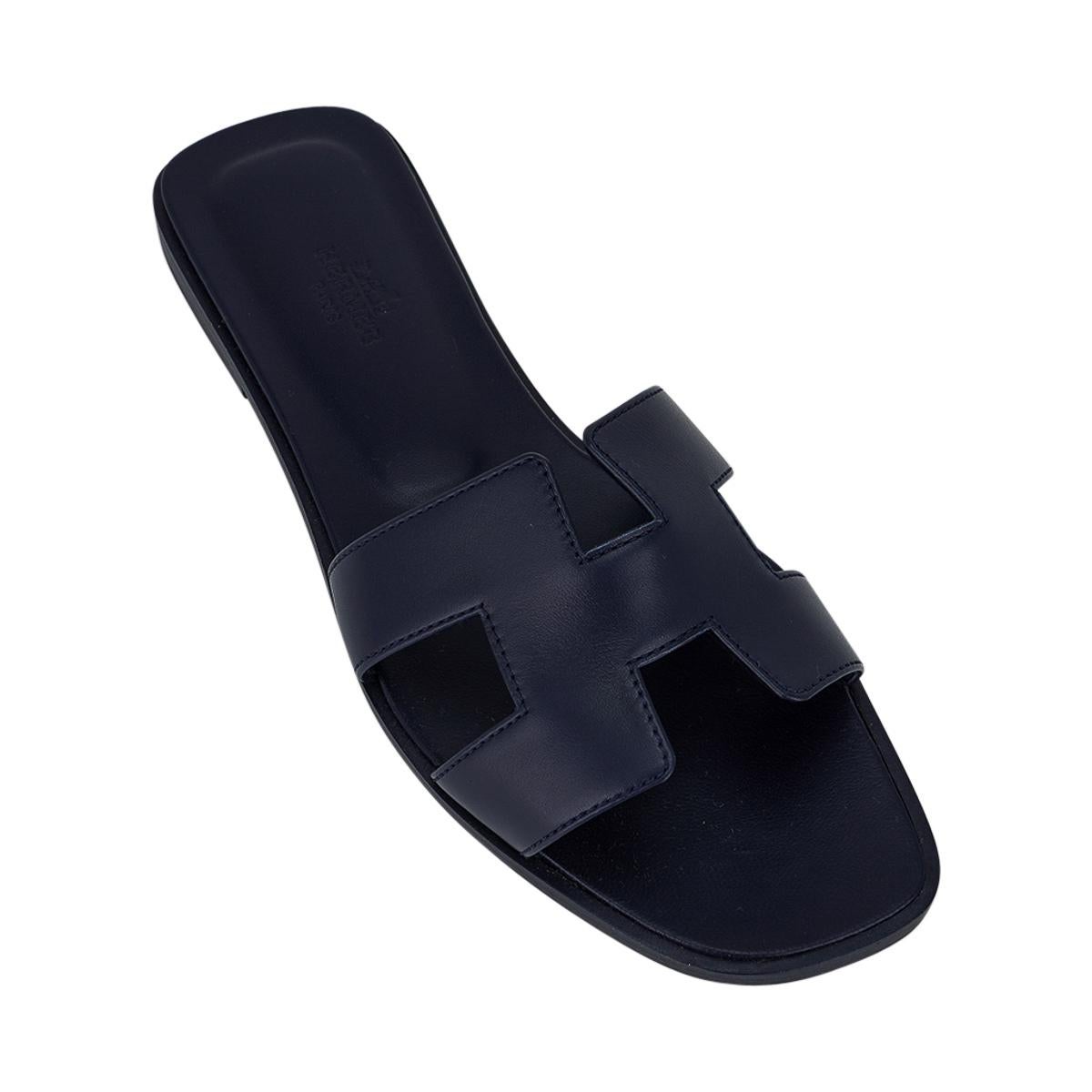 Mightychic offers Hermes Oran flat sandals featured in Bleu Marine.
This stunning box calfskin leather Hermes Oran slide sandal is in a richly saturated blue navy hue - stunning.
The iconic H cutout over the top of the foot.
Matching embossed