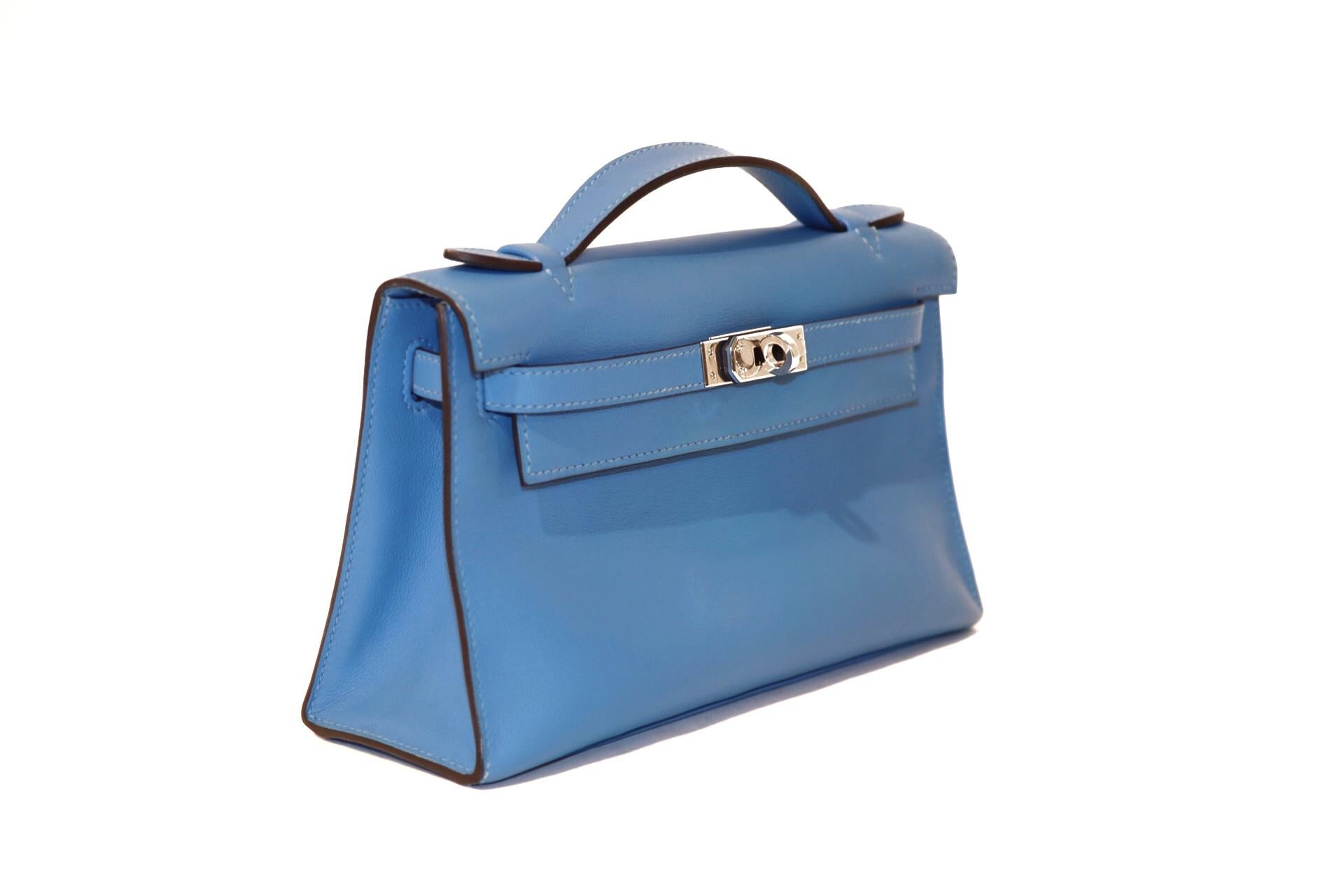 This authentic Hermès Blue Paradise Swift Kelly Pochette is in pristine condition, never before carried with protective plastic intact on the hardware.    Hermès bags are considered the ultimate luxury item worldwide.  Each piece is handcrafted with