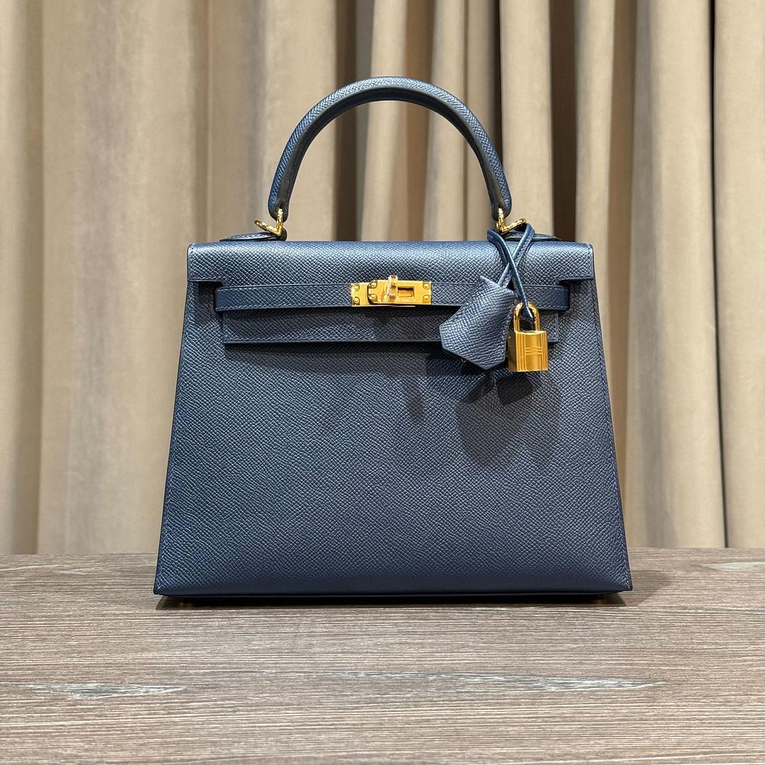 Jewels Aficionado bietet die Hermès Kelly Sellier 25 in Blue Sapphire Epsom Leder an, ein kühnes und doch elegantes Statement. Der tiefblaue Farbton passt hervorragend zur strukturierten Sellier-Silhouette, während das Epsom-Leder für Struktur und