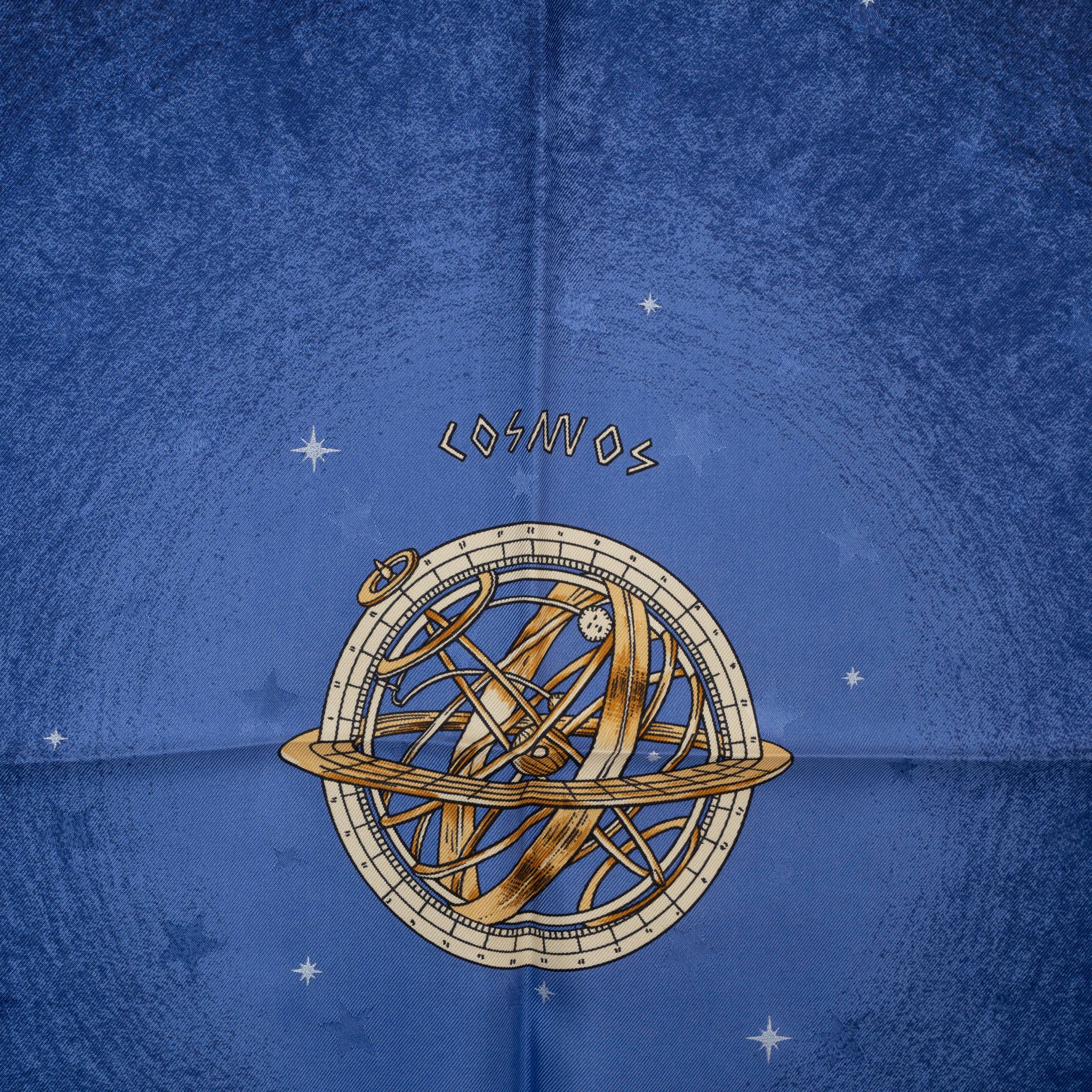 This 100% authentic Hermès Cosmos 90 scarf, designed by Philippe Ledoux, is crafted from luxurious midnight blue silk jacquard, intricately interwoven with stars. The celestial-inspired print features a stunning gold and light blue design, with a