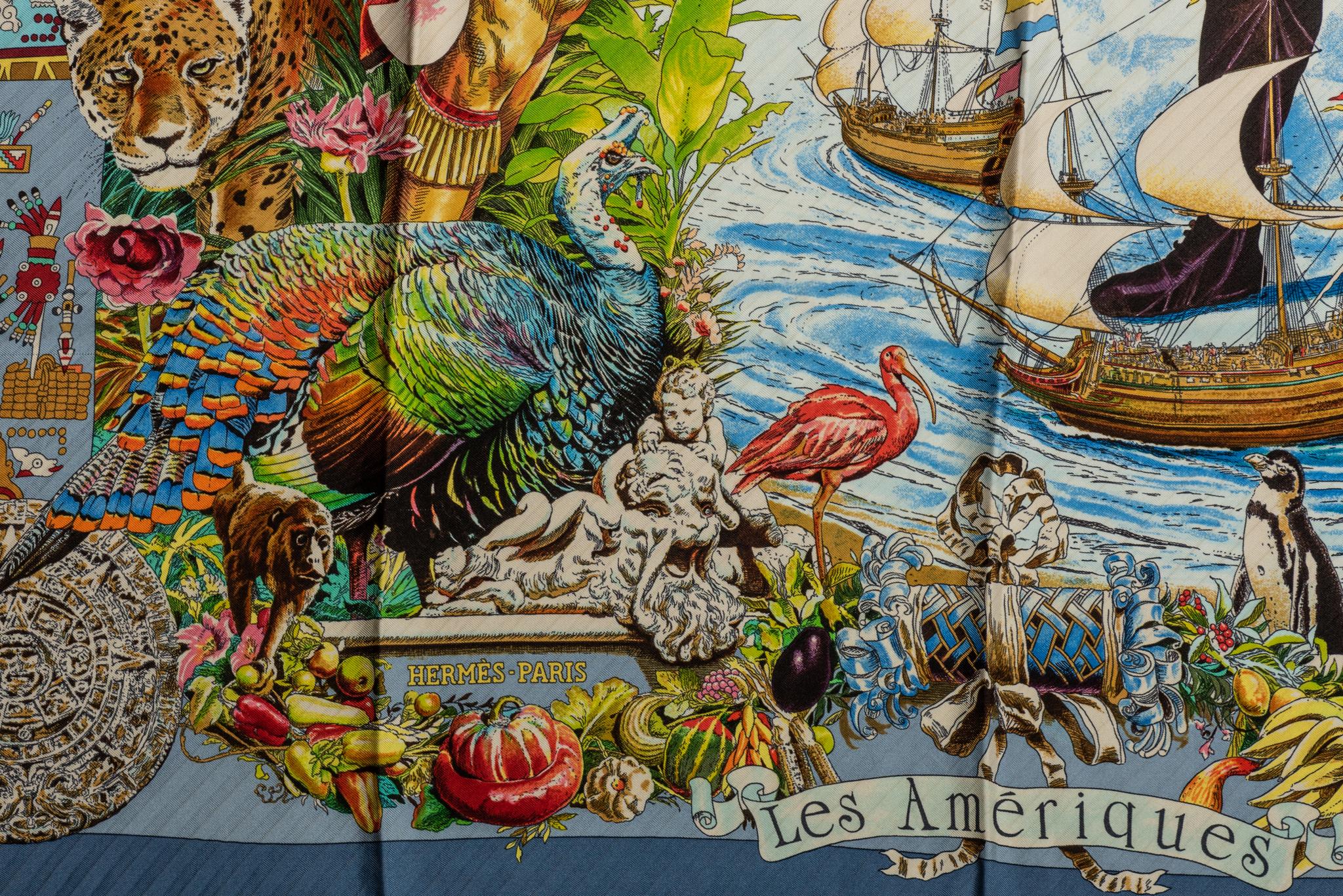 Foulard Hermès Les Ameriques en soie bleue, conçu par Kermit Oliver. Bords roulés à la main. Usure mineure.