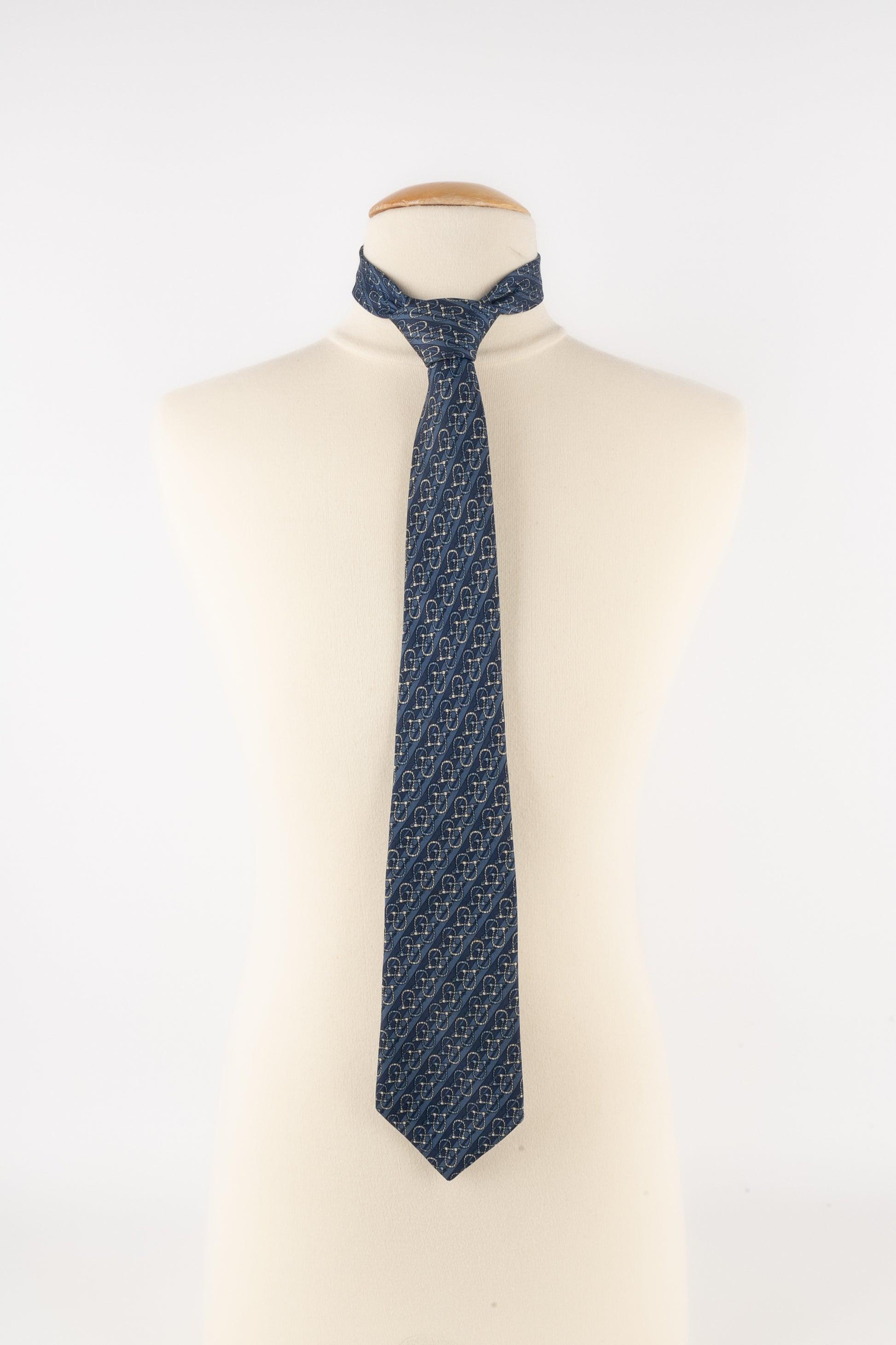 Hermès - (Made in France) Blue silk tie printed with snaffle bits.

Additional information:
Condition: Very good condition
Dimensions: Max. width: 9 cm

Seller Reference: ACC231
