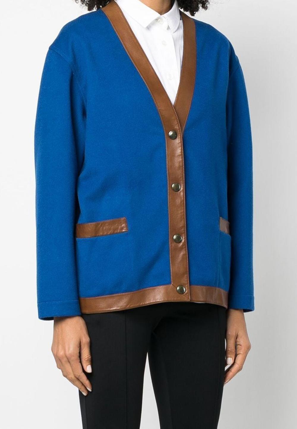 Hermes blue V-neck wool jacket featuring a camel leather trim, a V-neck, a front logo snap button fastening, long sleeves
and a straight hem.
Composition: 100% wool
 and trim: 100% leather 
Label size 38fr/US6 /UK10
In good vintage condition. Made