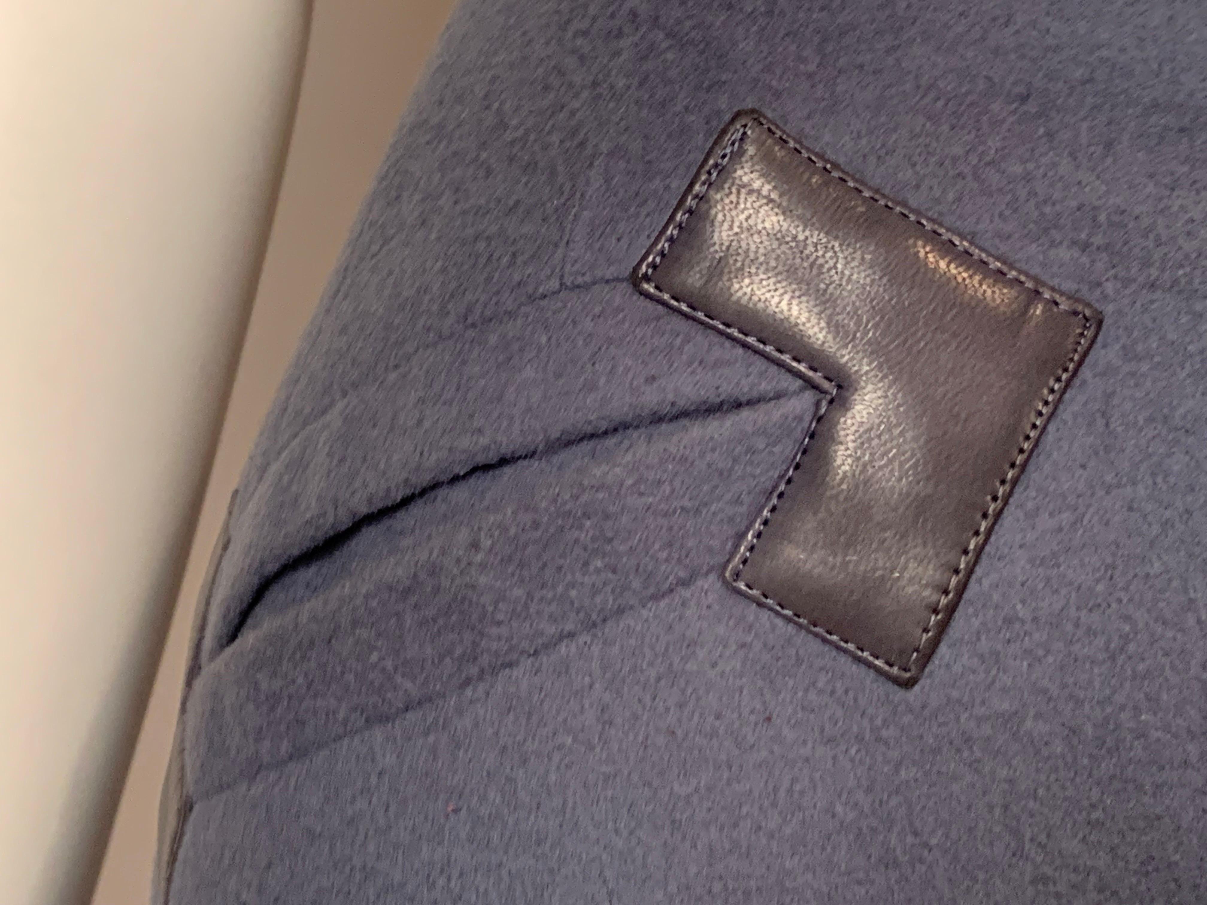 THis Hermes, Paris medium weight blue wool faux wrap skirt is trimmed with blue leather at the right hip pocket and the left side closure. Gold toned hardware are used to secure the skirt. There is a hidden hook and eye and zipper at the center