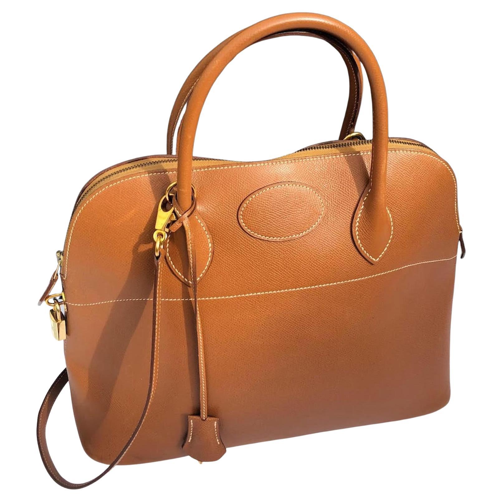 HERMÈS Bolide 1995 Tan Leather Bag GHW Vintage
A timeless classic vintage 1995 Hermès Bolide bag in cavalerie tan-gold colour in Courchevel leather with shoulder strap, key fob and keys. This 28 years old Bolide has kept its beautiful shape, the