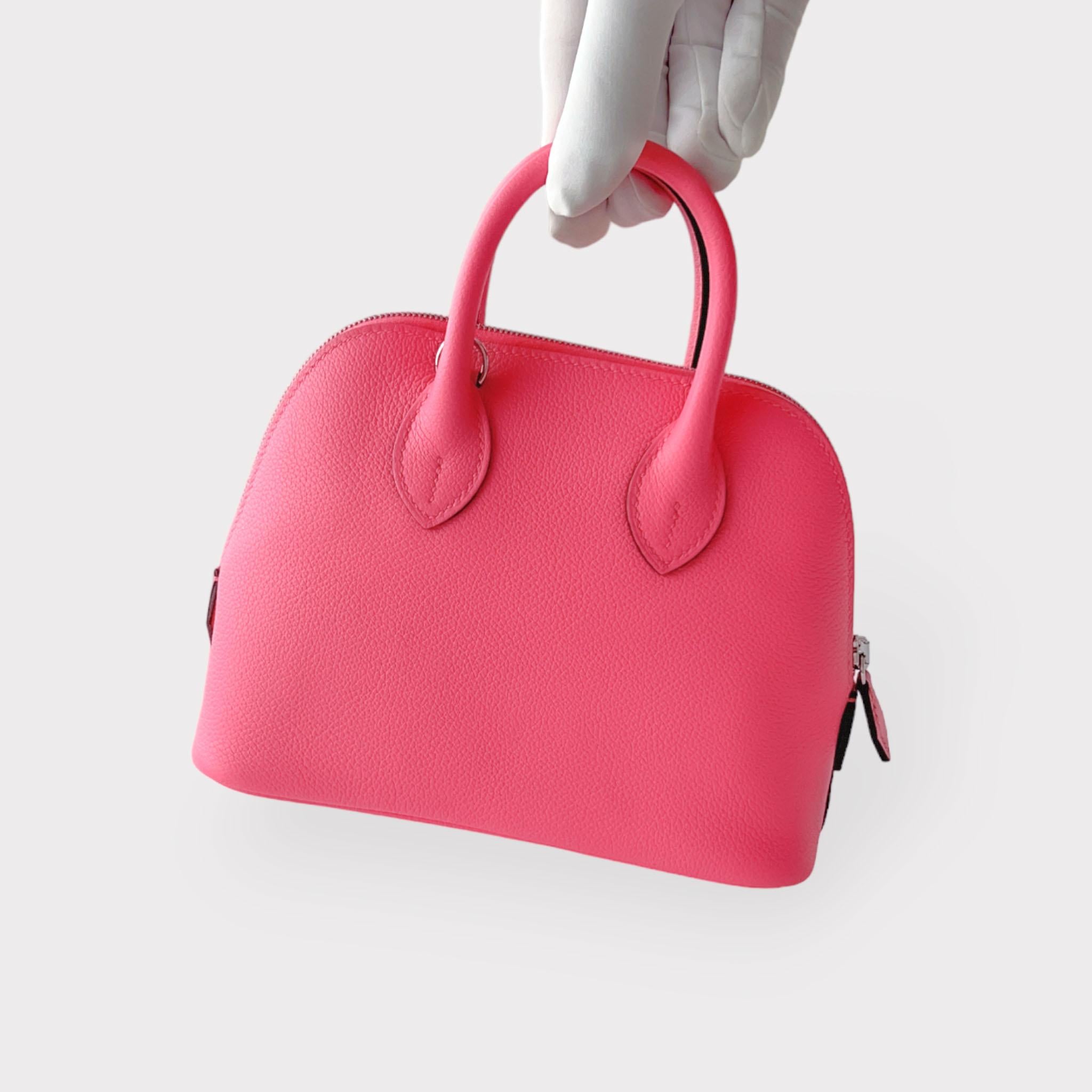 Shoppen Sie diese elegante Hermes Bolide Mini Bag 1923 in Rose Azalee, einem wunderschönen Bubblegum-Pink. Er ist perfekt mit Palladium-Beschlägen ausgestattet und besteht aus dem glatteren Evercolor-Leder. Der Mini Bolide In Rose Azalee (Pink) hat