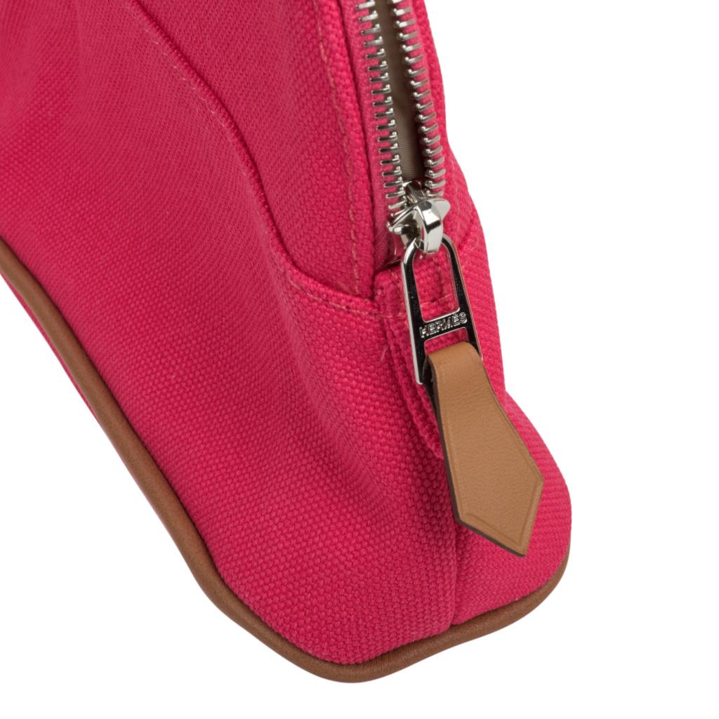 Guaranteed authentic Hermes Bolide travel case - Trousse de Voyage - features pink Hibiscus cotton.
Zipper toggle has lambskin leather pull and base has leather trim.   
This charming waterproof lined travel case has the embroidered H in front. 