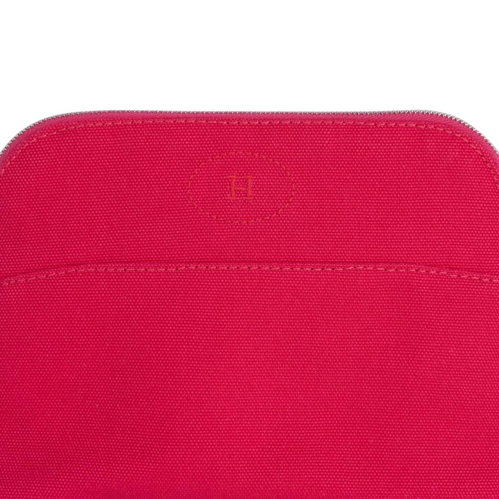 Hermes Bolide travel case medium model - Trousse de Voyage - features pink Hibiscus cotton canvas.
Zipper toggle has lambskin leather pull and base has leather trim.   
This charming waterproof lined travel case has the embroidered H in front.  
New