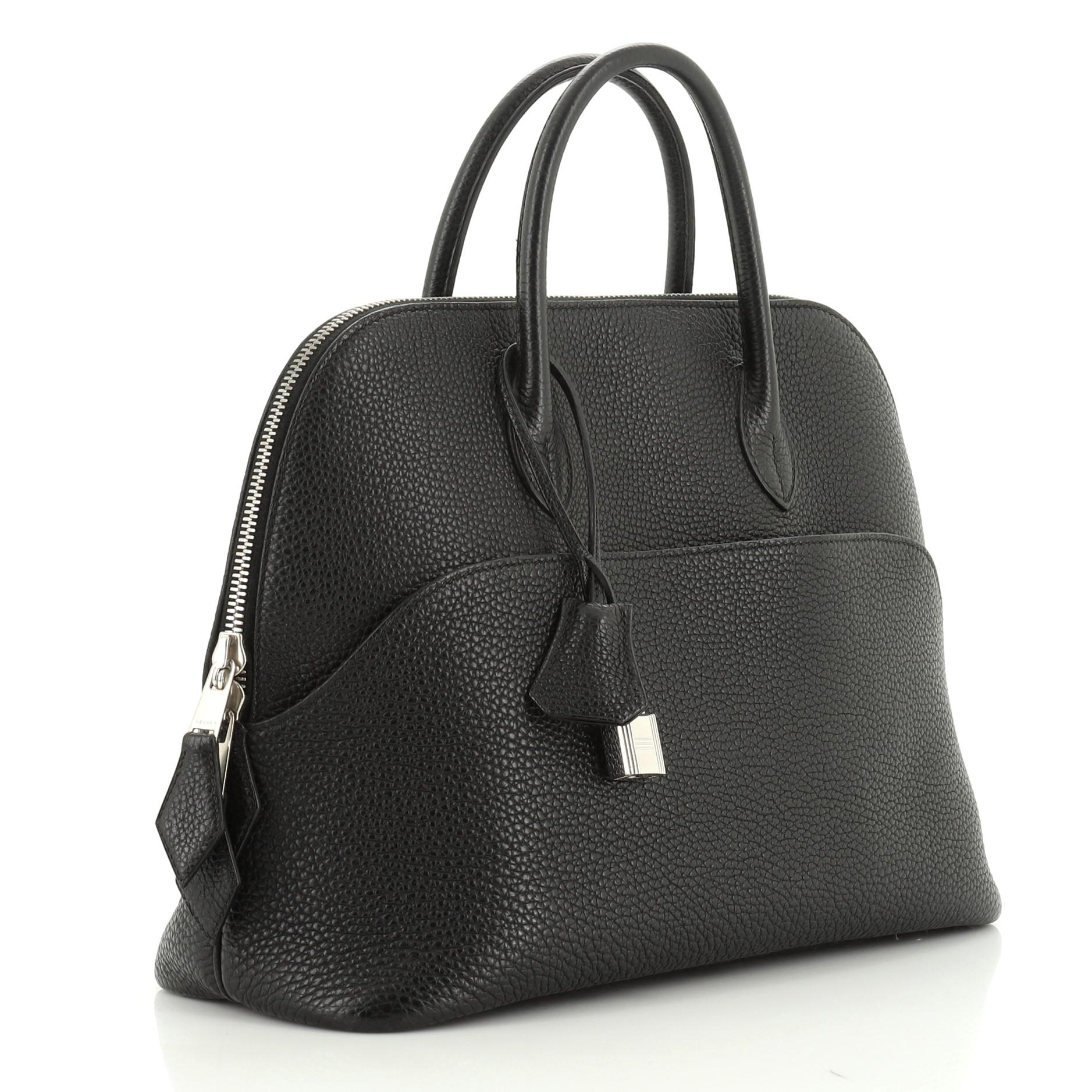 This Hermes Bolide Web 1923 Handbag Togo 31, crafted from Noir black Togo leather, features dual rolled leather handles and palladium hardware. Its zip closure opens to a Noir black Chevre leather interior. Date stamp reads: I Square (2005).