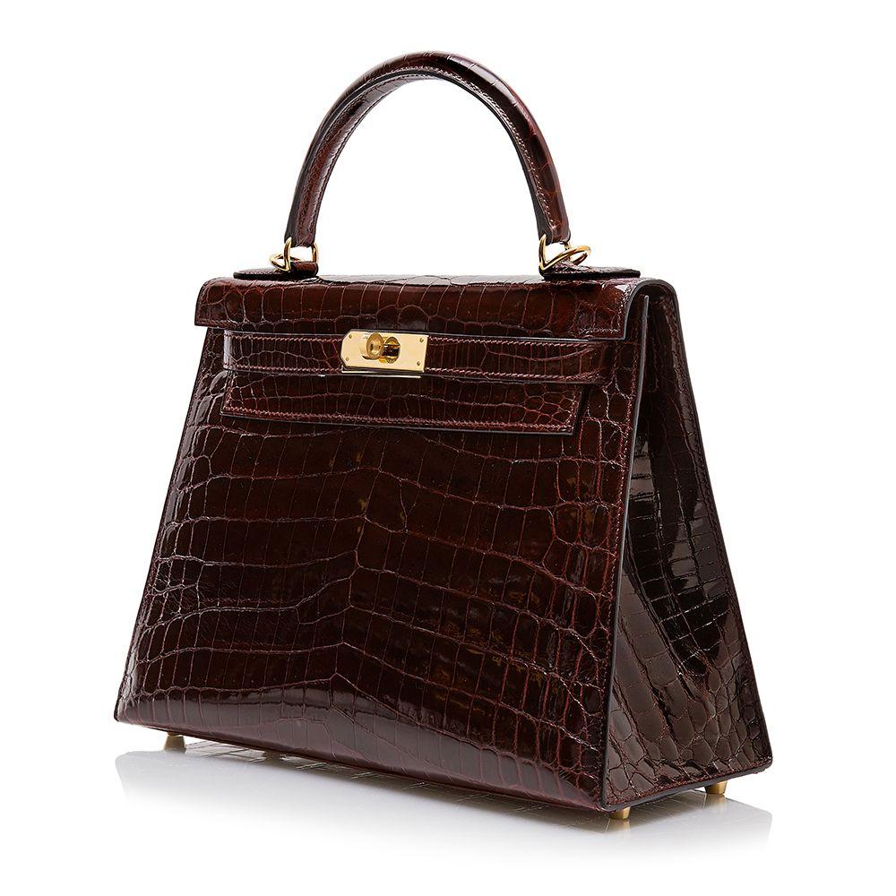 Crafted in France from Shiny Niloticus leather, a rare  Hermès skin, notorious for its large scales and noticeably glossy finish. this structured, Kelly Sellier bag features rigid corners and matching stitching with concealed piping. Featuring a