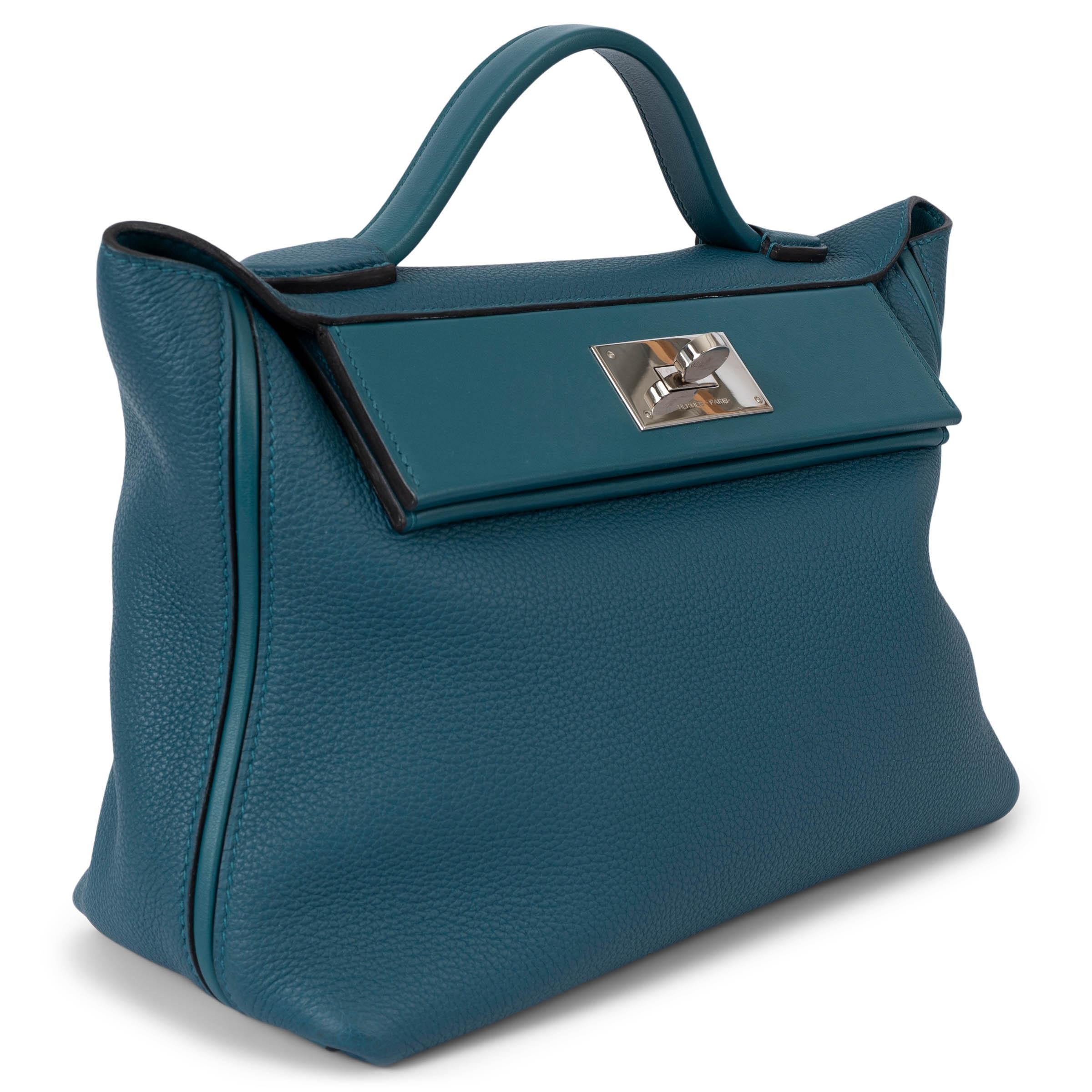 100% authentic Hermès 24/24 29 bag in Vert Bosphore (petrol green) Togo and Swift leather with a slip pocket at the back. Opens with a turn-lock in Palladium and is lined in Vert Bosphore Swift with one zipper pocket against the back. Has been