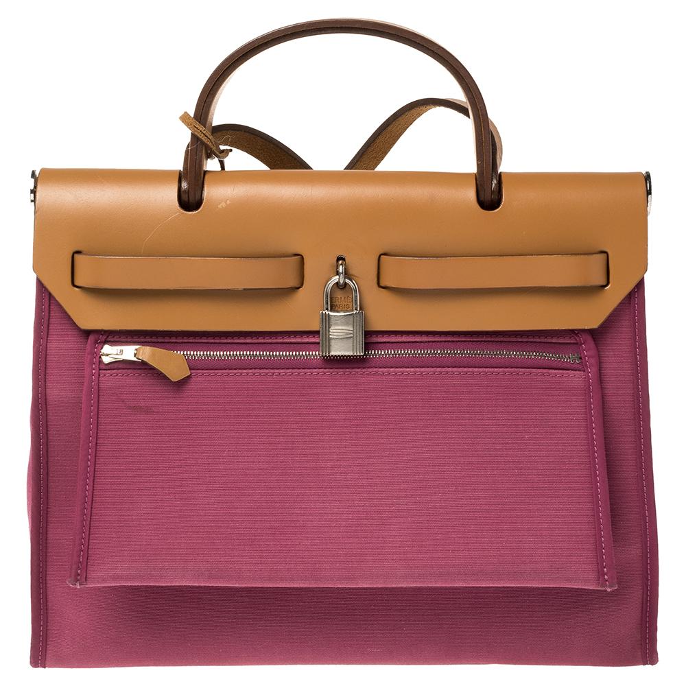 Fabricado en lona rosa y piel, el Herbag Zip es tan extraordinario como todos los demás bolsos de Hermes. Presentado por primera vez en 2009 como una nueva versión del Herbag, esta pieza viene con una sola asa, una larga correa para el hombro y