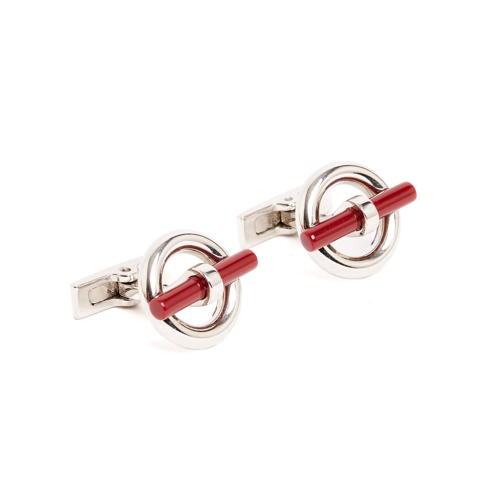 Hermès Flibustier cufflinks in silver-plated metal and coral-colored resin, engraved with the Hermès brand and an H on the back. The buckles are in very good condition and come in a Hermès box.
