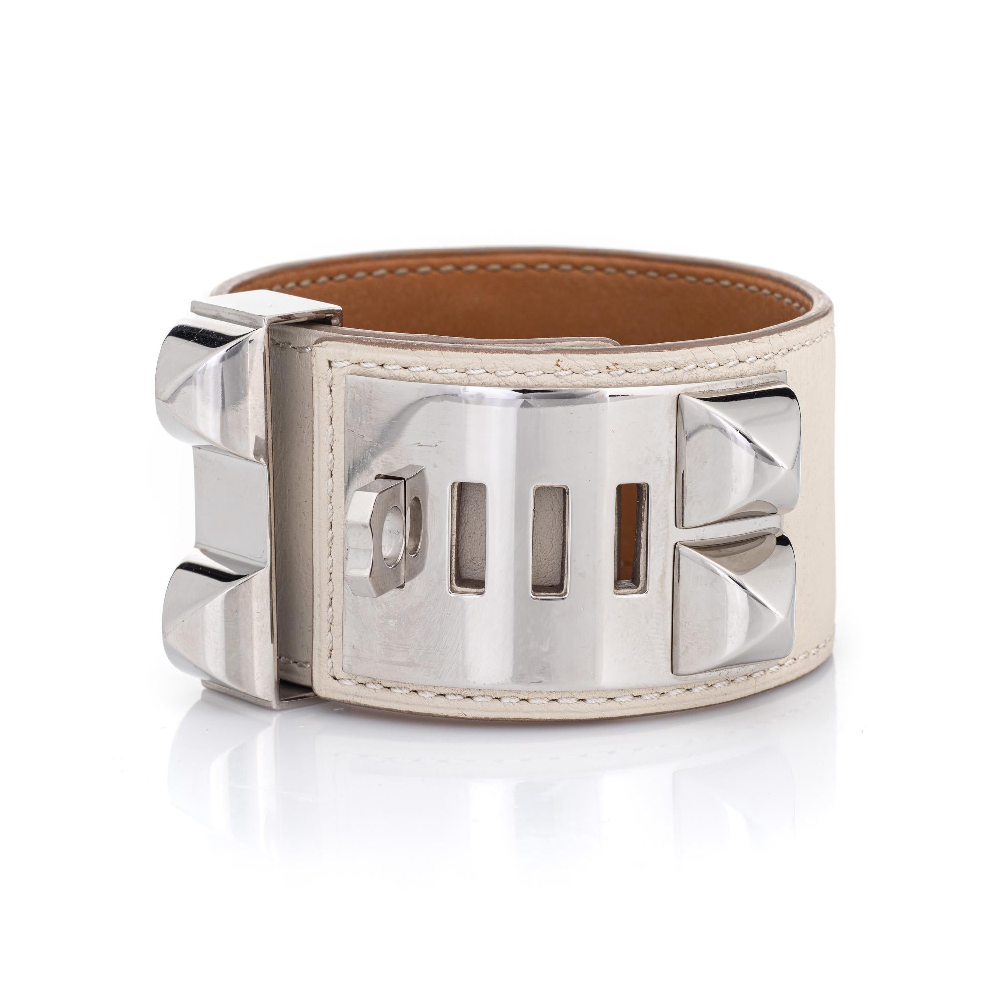 Overview:

Pre-owned Hermes Collier de Chien white leather cuff bracelet finished with palladium-plated hardware. Also included is the Hermes brown felt travel pouch. 

The wide 1.50-inch bracelet features an adjustable length from 7 inches to 8