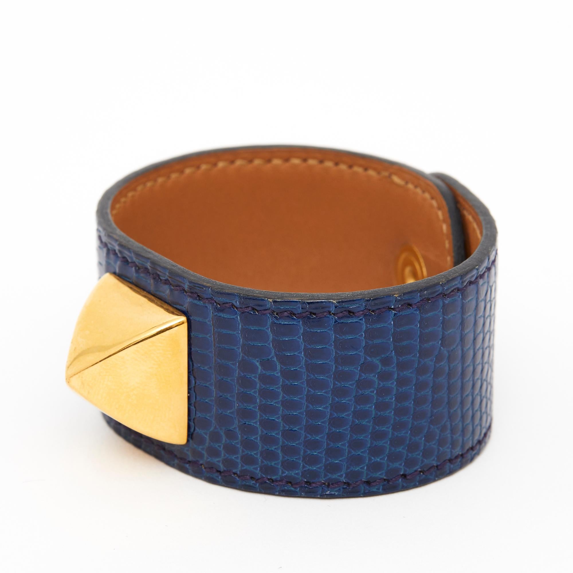Hermès Médor model bracelet in lustrous oil-colored lizard adorned with a diamond-point stud in gold metal, fitted to the wrist with a saddle nail-style snap closure. Length 17.2 cm, Height 2.8 cm. Apart from the slightly scratched pressure, the