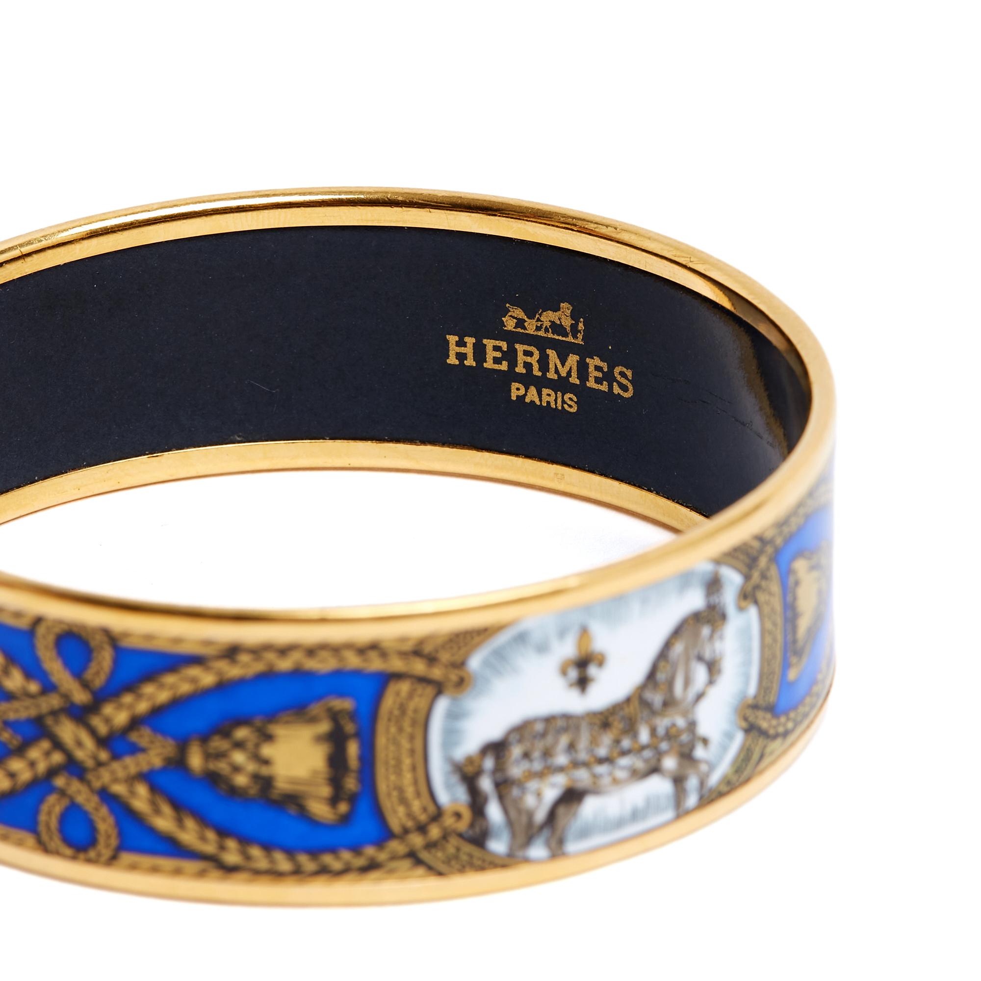 Hermès bracelet, Large model, in printed enamel, Grand Apparat motif in shades of Prussian blue, gray and gold, gold-plated metal. Size 70: inner diameter 6.8 cm, height 2.2 cm. The bracelet has been worn and it has some traces of use but nothing