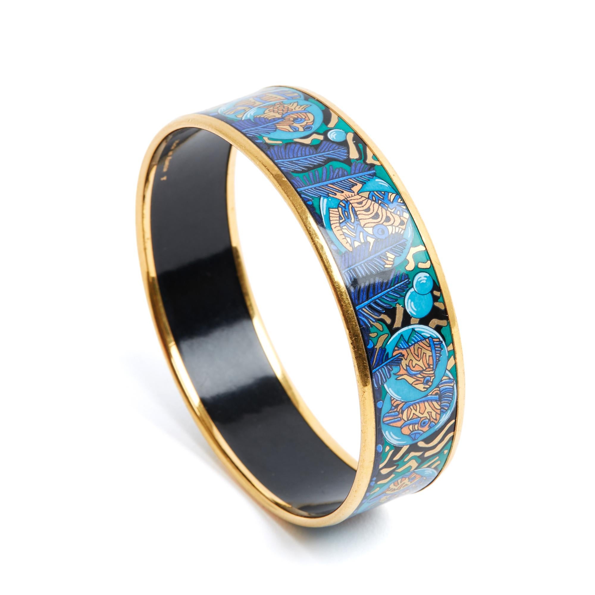 Hermès Large model bracelet in printed enamel, coral and exotic fish motif in shades of blue, black and gold, gold-plated metal. Size 65 or S: inner diameter 6.3 cm, height 1.9 cm. The bracelet has been worn and it has gaps that have been filled