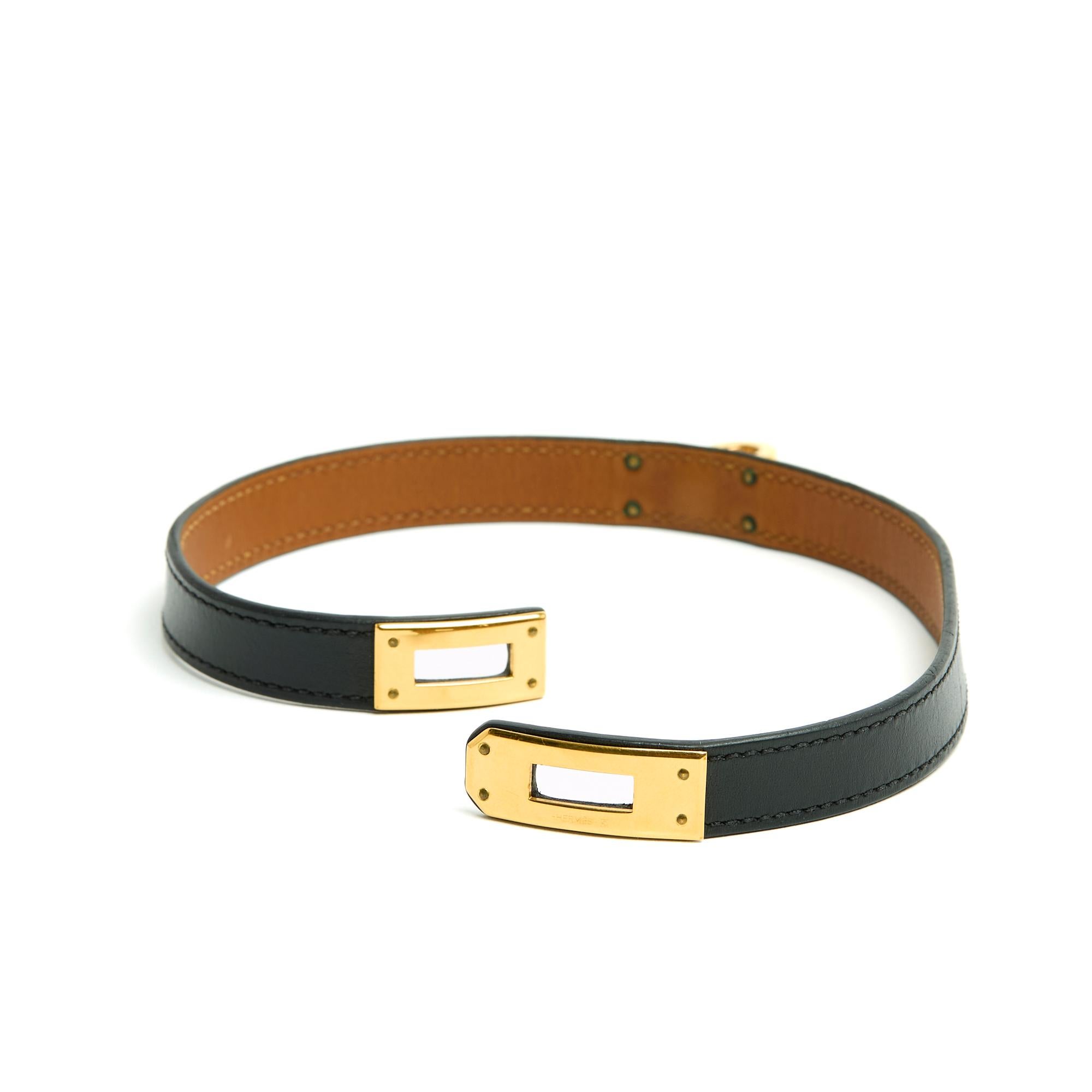 Hermès Kelly double-wrap bracelet in smooth black leather and gold metal, size 2 (for a 15.5 cm or 6.1 in wrist), leather width 1.2 cm, year 2013, delivered in its original pouch and box. The metal parts have tiny scratches and the bracelet may be
