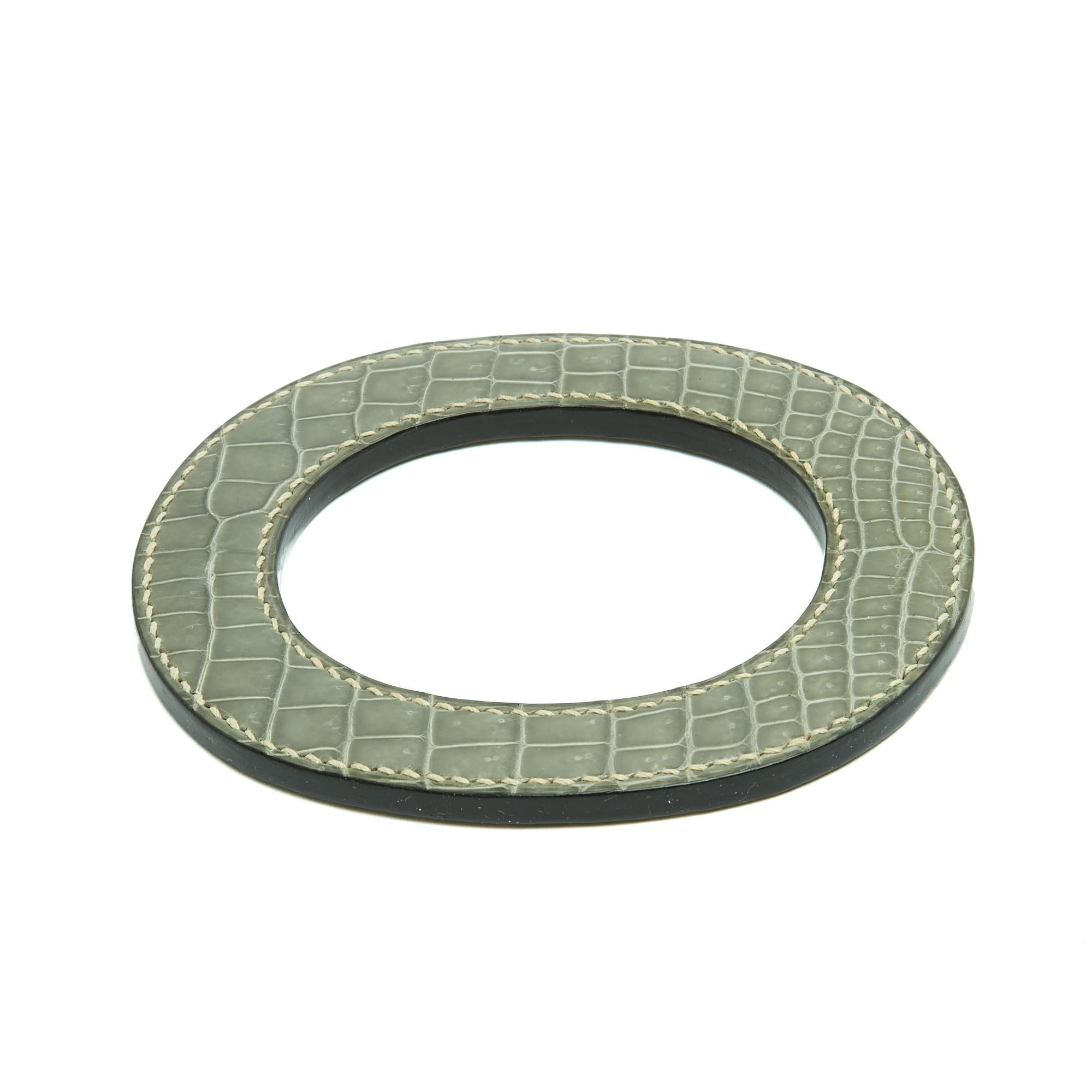 Bracciale (o ciondolo?) Hermès Isthme in pelle verde Sage, 2007, in ottime condizioni. Dimensioni interne 7,4 x 6 cm, dimensioni esterne 11,2 x 9,4 cm, spessore 0,5 cm. Il braccialetto (o l'anello foulard, il ciondolo, etc.) è in perfette