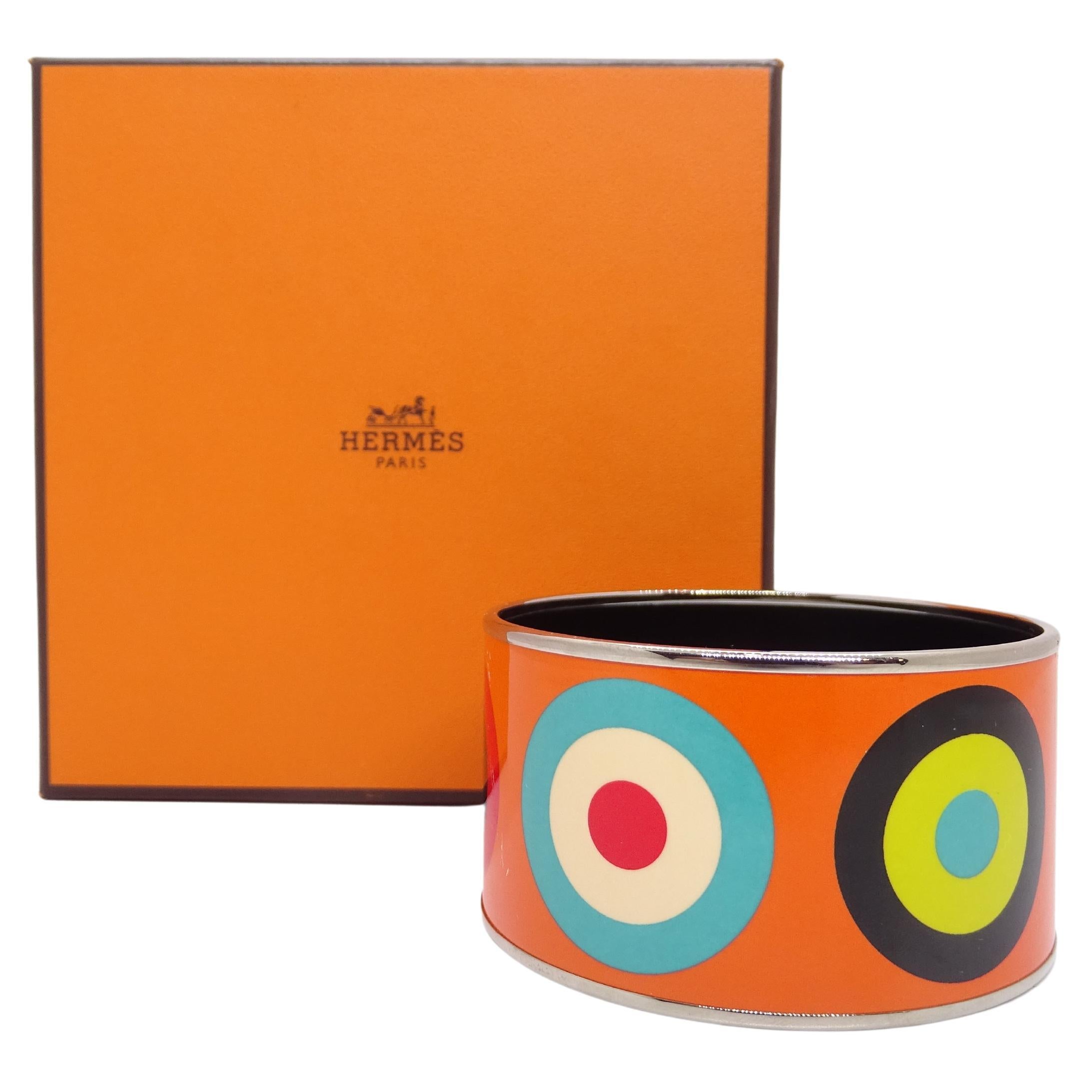  Outstanding Hermès bracelet, s. XXI – France

Gorgeous  bracelet from the French house Hermes in palladium silver and enamel. Colorful circle design on the Hermès orange background. These concentric circles in beige, red, black, blue and green on