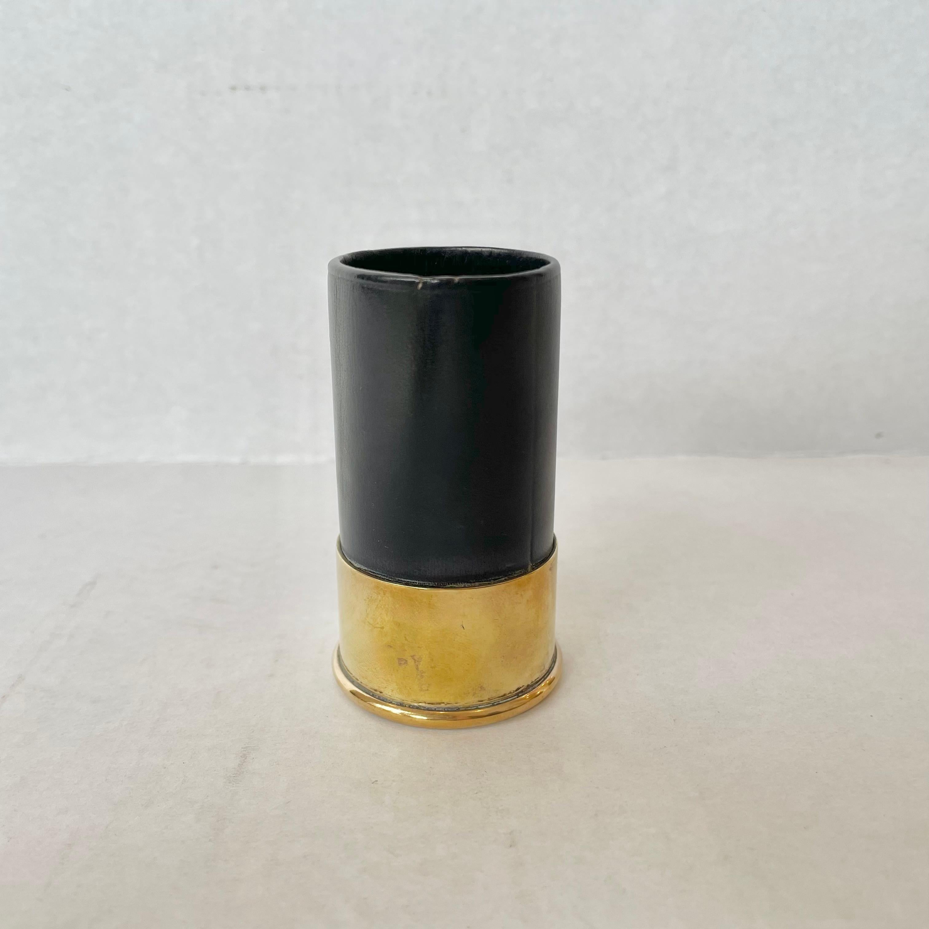 Classic leather cup with brass bottom made by Hermès. In the shape/style of a shotgun shell. Stamped Hermès Made in France on underside of brass. Good vintage condition. Great desktop item with functionality and fun design. Fun piece of collectible