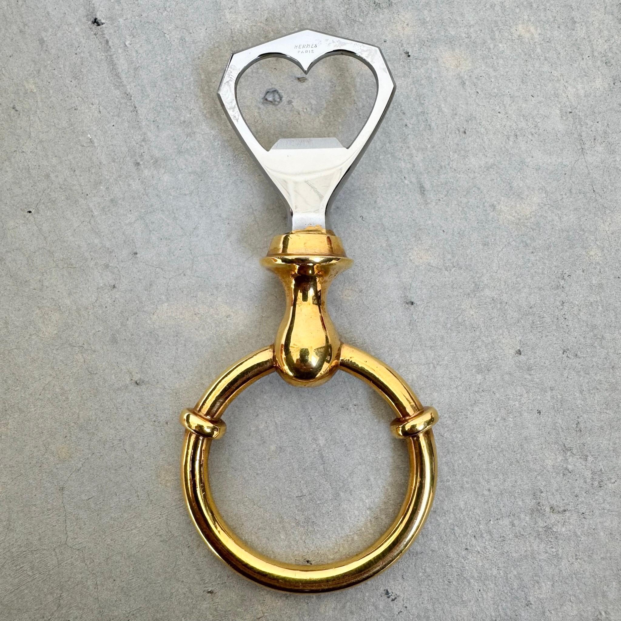 Add a luxurious touch to your home bar with this lovely bottle opener. The perfect gift for someone special in your life and for any vintage Hermès aficionado. In honey-colored brass and bright steel, a round loop at the bottom serves as a
