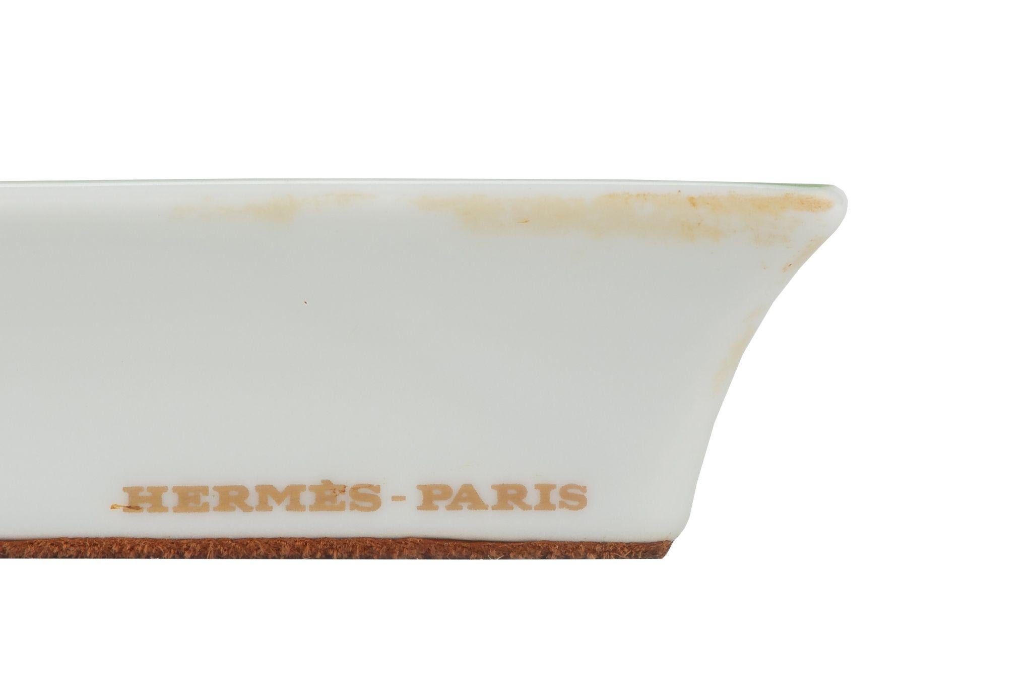 Hermès Brazil Porcelaine ashtray. The piece is square and the paint shows a big pheasant in the center opening is feathers. The tray is in excellent condition with minor wear on the back suede.