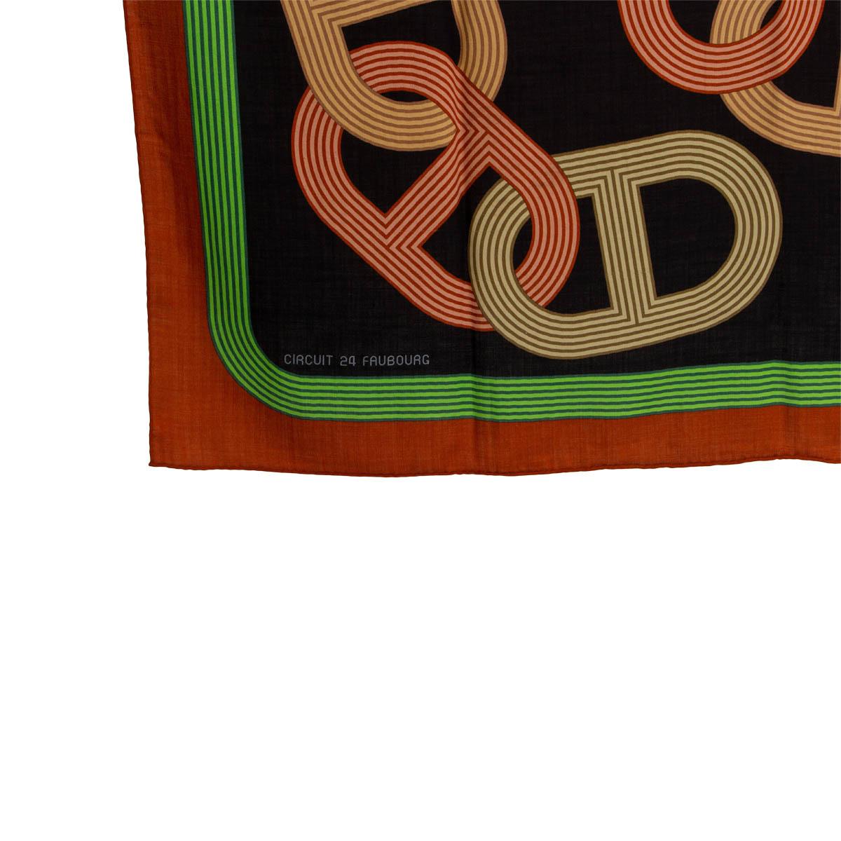 100% authentischer Hermès Circuit 24 Faubourg 140' Schal von Benoit Pierre Emery aus schwarzem Kaschmir (65%) und Seide (35%) mit ziegelfarbener und grüner Bordüre und Details in Gelb, Beige, Braun und Olivgrün. Wurde mit einigen Fadenziehungen