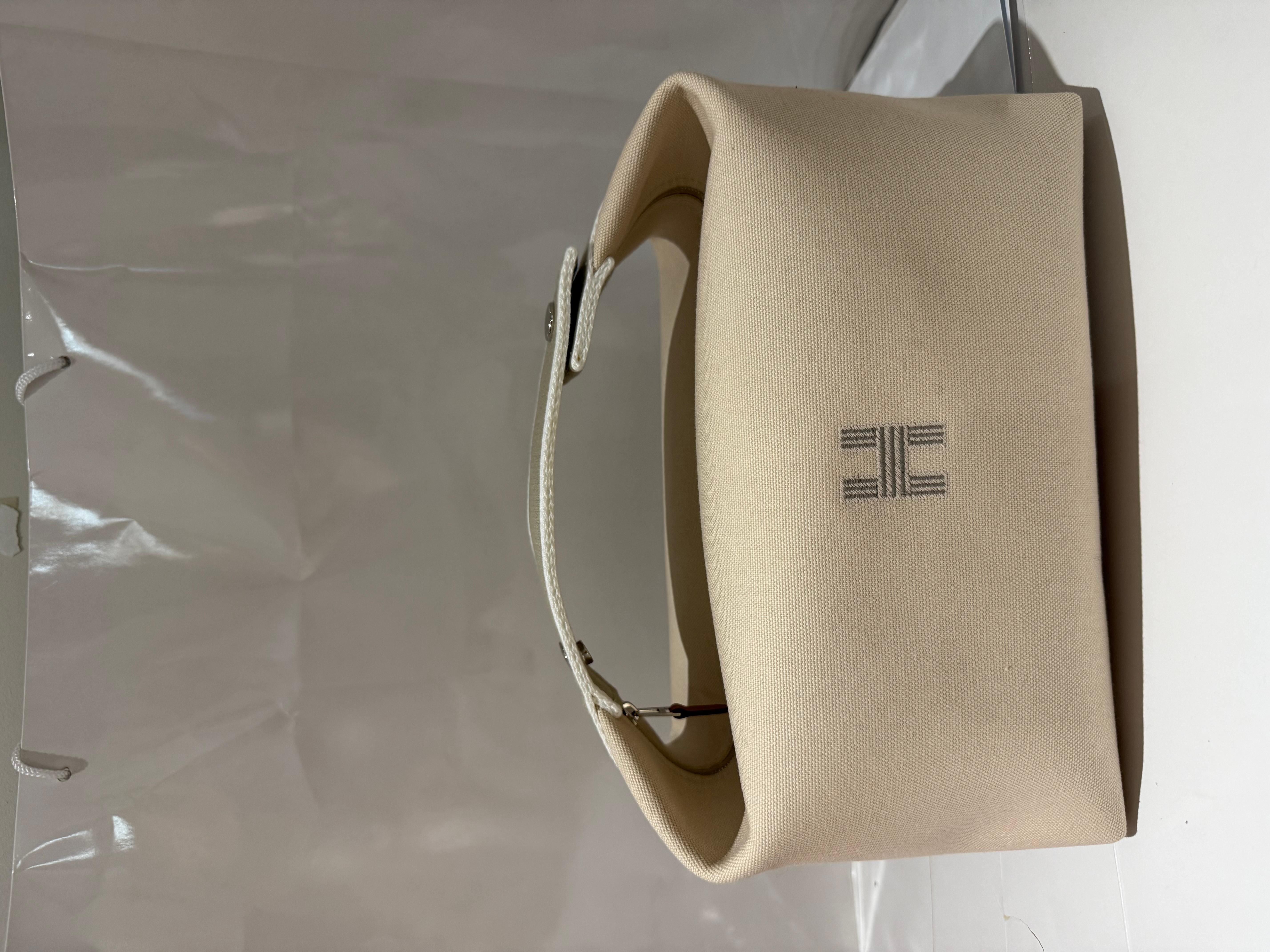 La pochette Hermes Bride A Brac Nature / Blanc / Gris Canvas GM présente une élégante combinaison de couleurs grises et ivoires, complétée par des ferrures argentées. Fabriqué en toile H, il est doté d'une fermeture à glissière pour un rangement