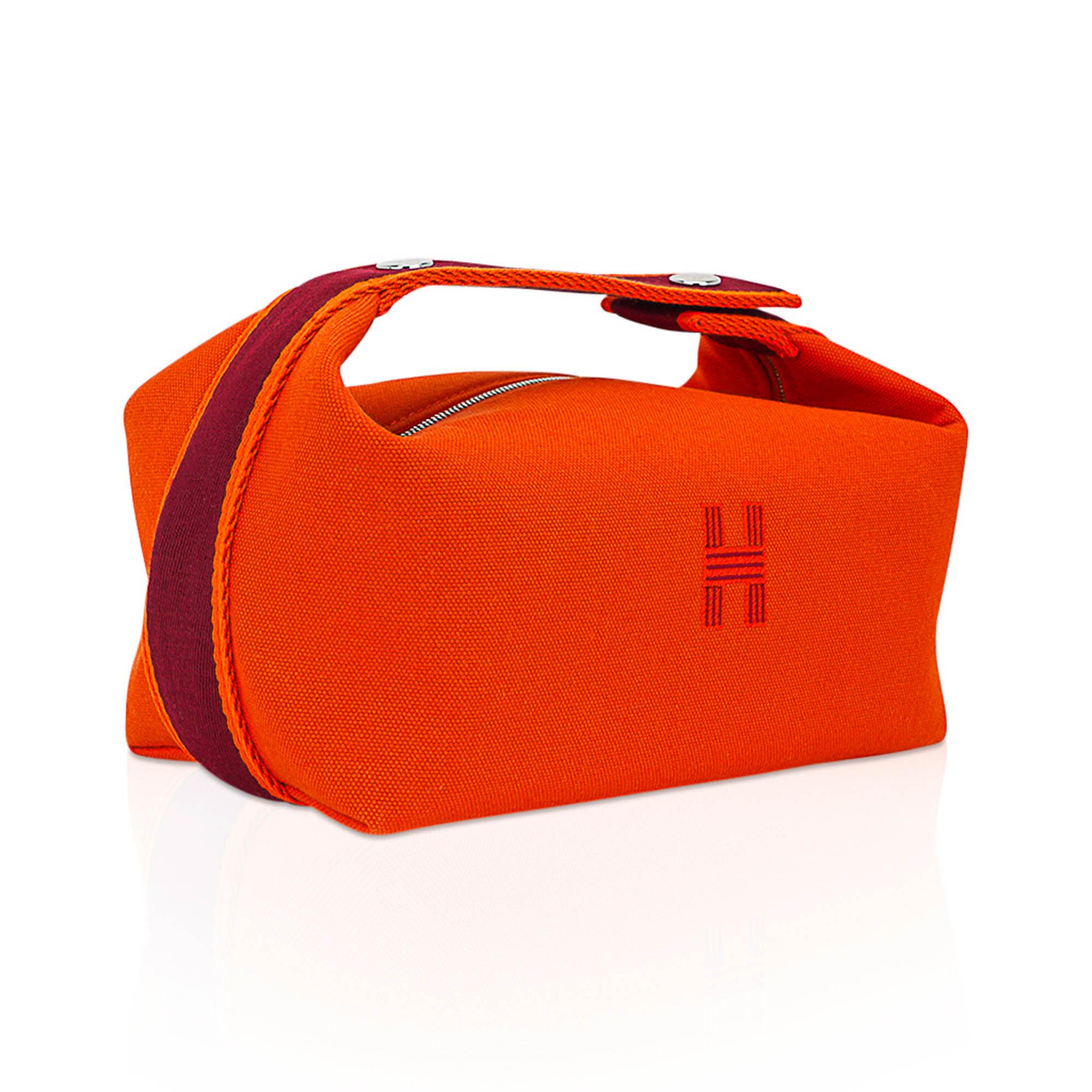 Mightychic offers an Hermes Bride-A-Brac Pencil Case small model featured in Orange H Plume cotton canvas.
The Trousse de Toilette has an embroidered H on the front.
Top strap, inspired by a Gianpaolo Pagni drawing, features an woven Rouge zig