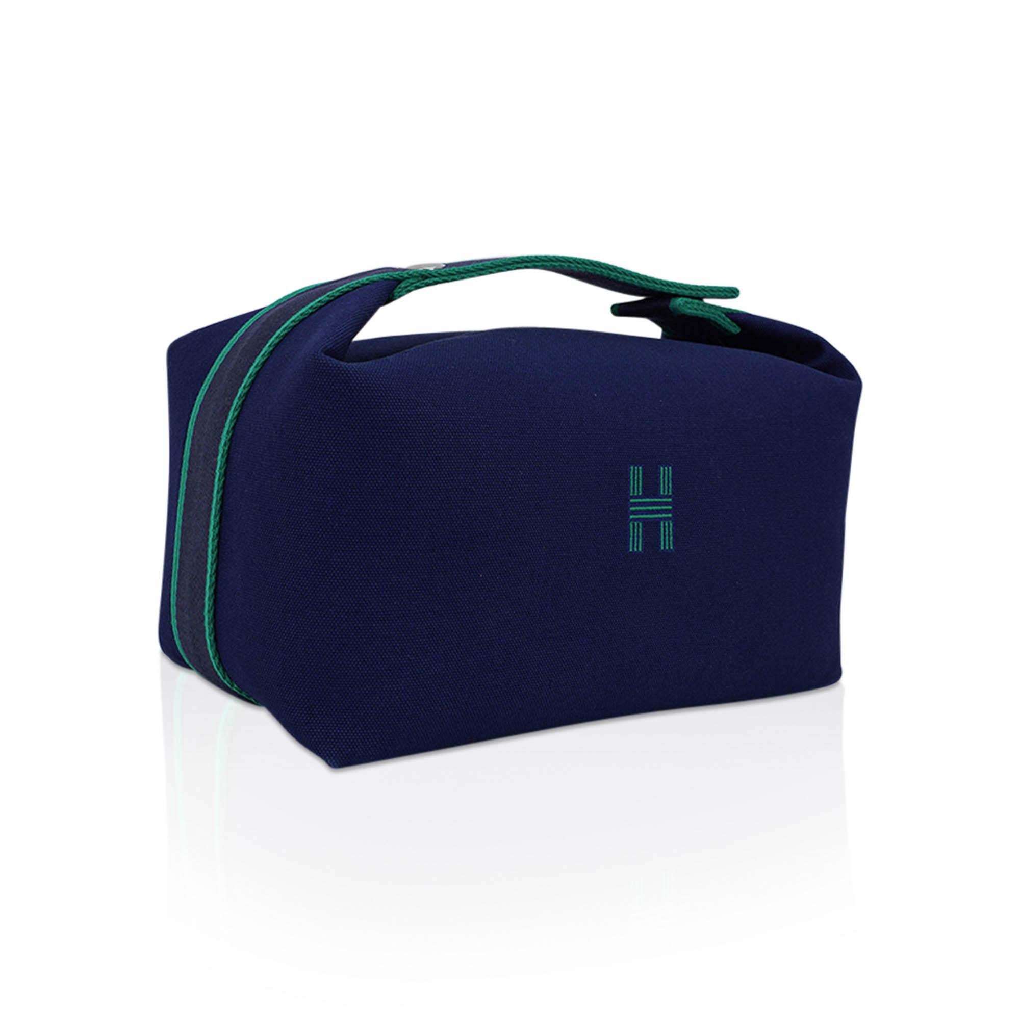 Mightychic offers an Hermes Trousse de Toilette case featured in Marine H Plume canvas.
Embroidered H on the front.
Top strap, inspired by a Gianpaolo Pagni drawing, features a woven Green zig zag.
With two Clou de Selle snaps, the strap opens over