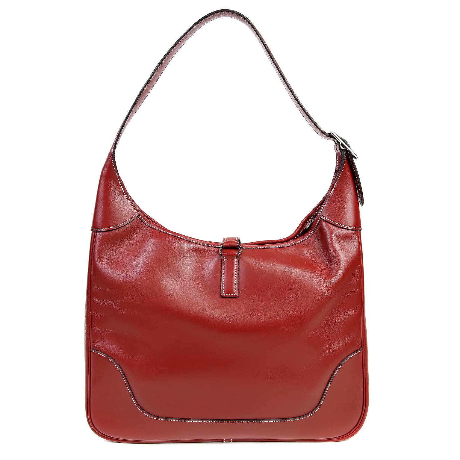 This authentic Hermès Burgundy Leather 31 cm Trim Bag is in pristine condition. Originally inspired by the feed bag style used by equestrians, the Trim has become synonymous with the most chic and fashionable icons of our time including Jackie