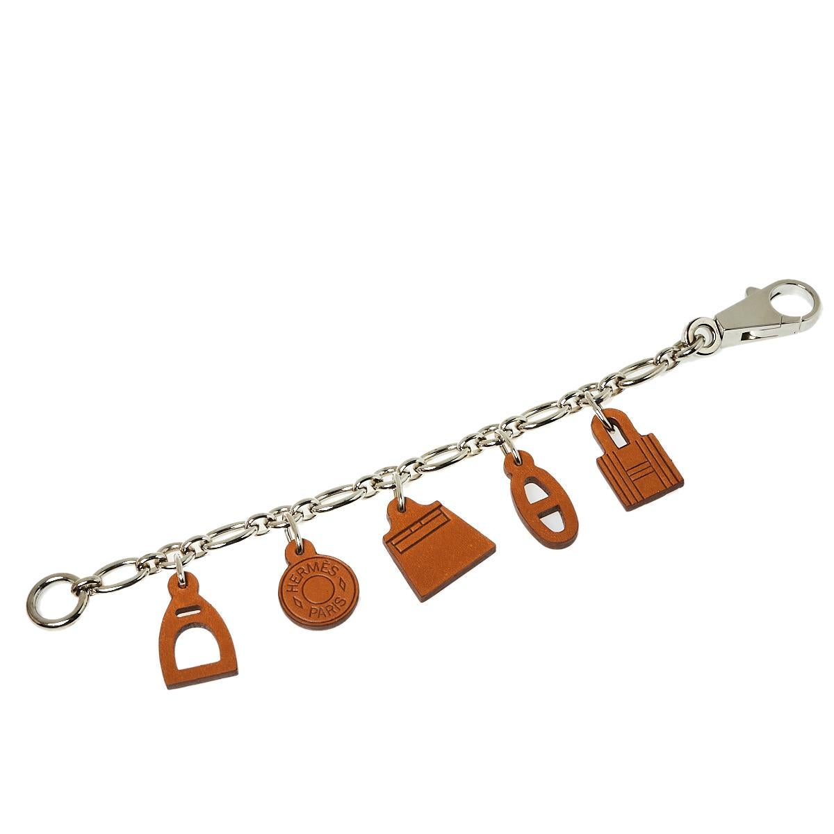 Let your pretty bag enjoy the company of this lovely Barenia Breloque Olga Amulette bag charm by Hermes. Made from si;ver-tone metal, the chain holds signature motifs rendered in quality leather. Eye-catching and easy to attach, this bag will make a