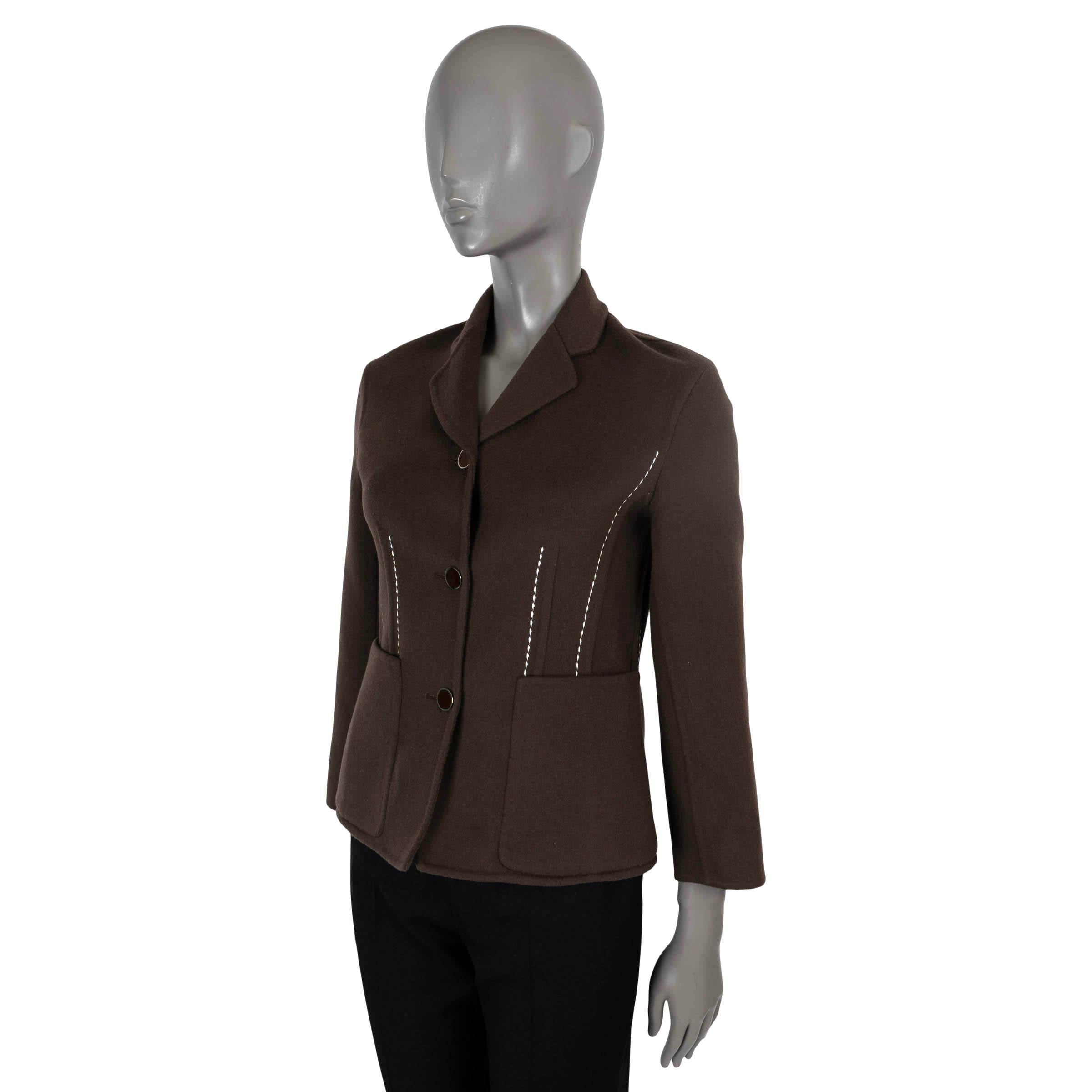 100% autentica giacca Hermès in cashmere marrone (100%). Presenta una silhouette sartoriale accentuata da cuciture simili a quelle delle stecche, evidenziate da impunture bianche a contrasto, revers a lancia e due tasche aperte in vita. Si chiude