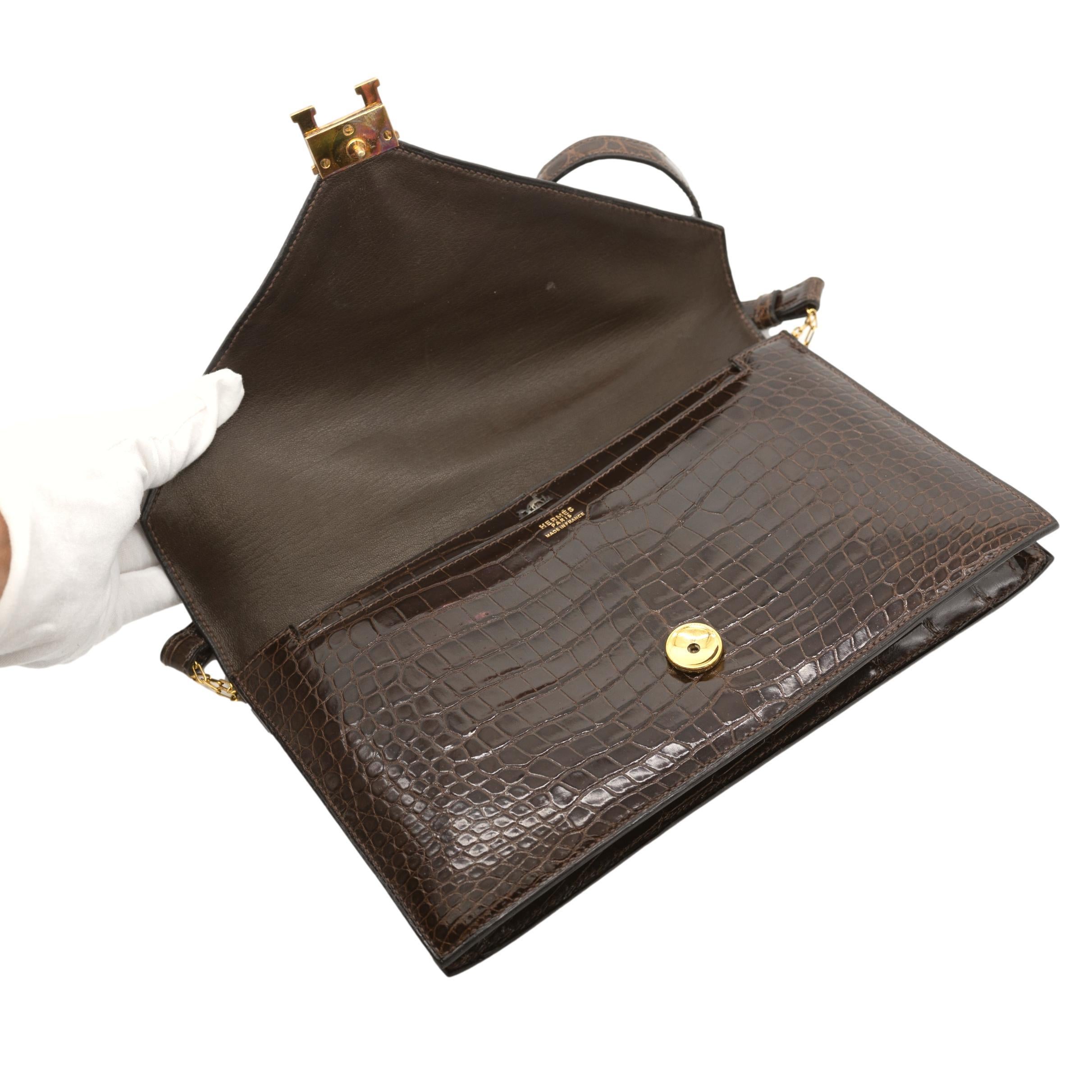 Hermès Brown Crocodile Lydie Crossbody Envelope Shoulder Bag, 1980. This collectors piece is truly an exceptional representation of the Hermès craftsmanship and attention to detail. The structure of the Lydie is bold and elegant, perfect for formal