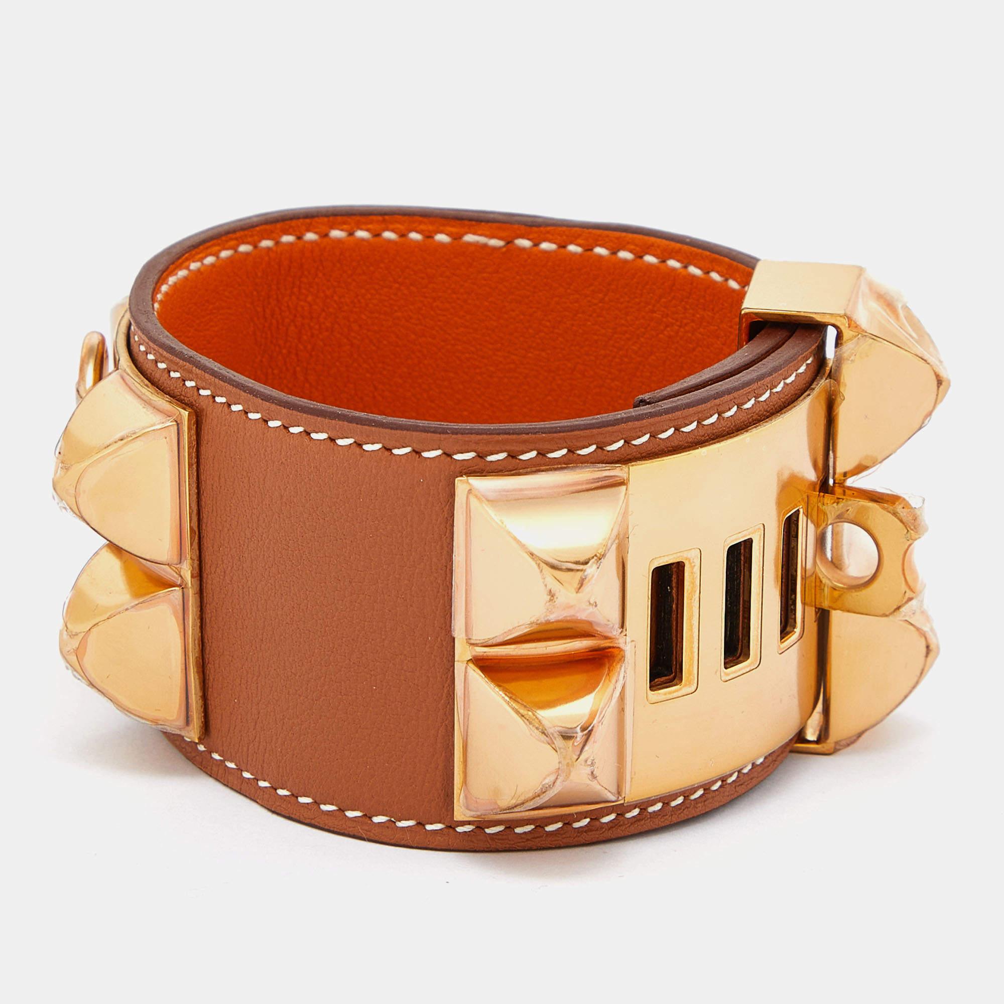 This instantly recognizable bracelet is from the signature Collier de Chien collection of Hermès. The bracelet, made of brown leather, is adorned with the iconic Collier de Chien motif in gold-plated metal featuring pyramid studs and a ring. This