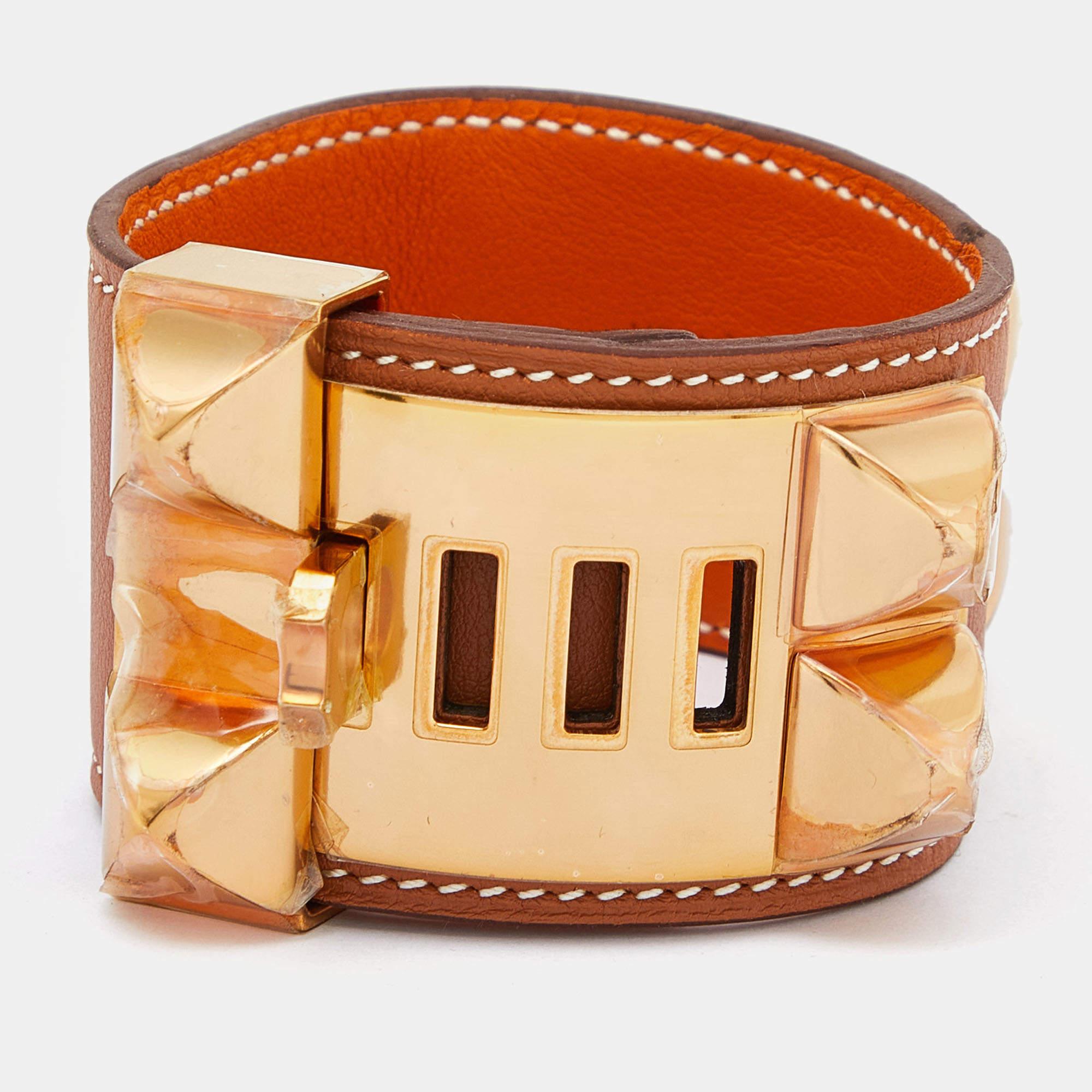 This instantly recognizable bracelet is from the signature Collier de Chien collection of Hermès. The bracelet, made of brown leather, is adorned with the iconic Collier de Chien motif in gold-plated metal featuring pyramid studs and a ring. This