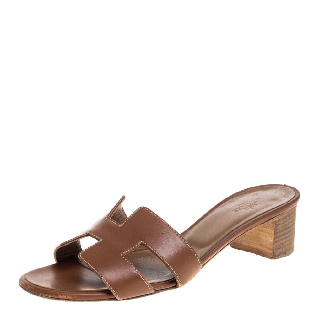 These brown leather slides from Hermès are a pair of simple and casual shoes. These slides have H straps on the vamps with contrasting white stitching. It is finished with open toes and 5 cm block heels.

