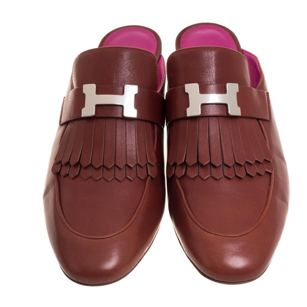 Mules are a coveted style and we can see why. They are super comfortable, classy, and can work all day without any hassle, just like these Hermes ones. They are crafted from brown leather and feature round toes, fringe accents and signature H