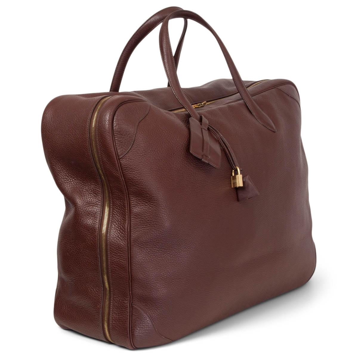 100% authentic Hermes Victoria 50 travelt bag in Havane (chestnut brown) Taurillon Clemence leather. Opens with a zipper. Lined in ivory fabric with two elastic straps. Has been carried and the bottom has fold and press marks as well as corner wear.
