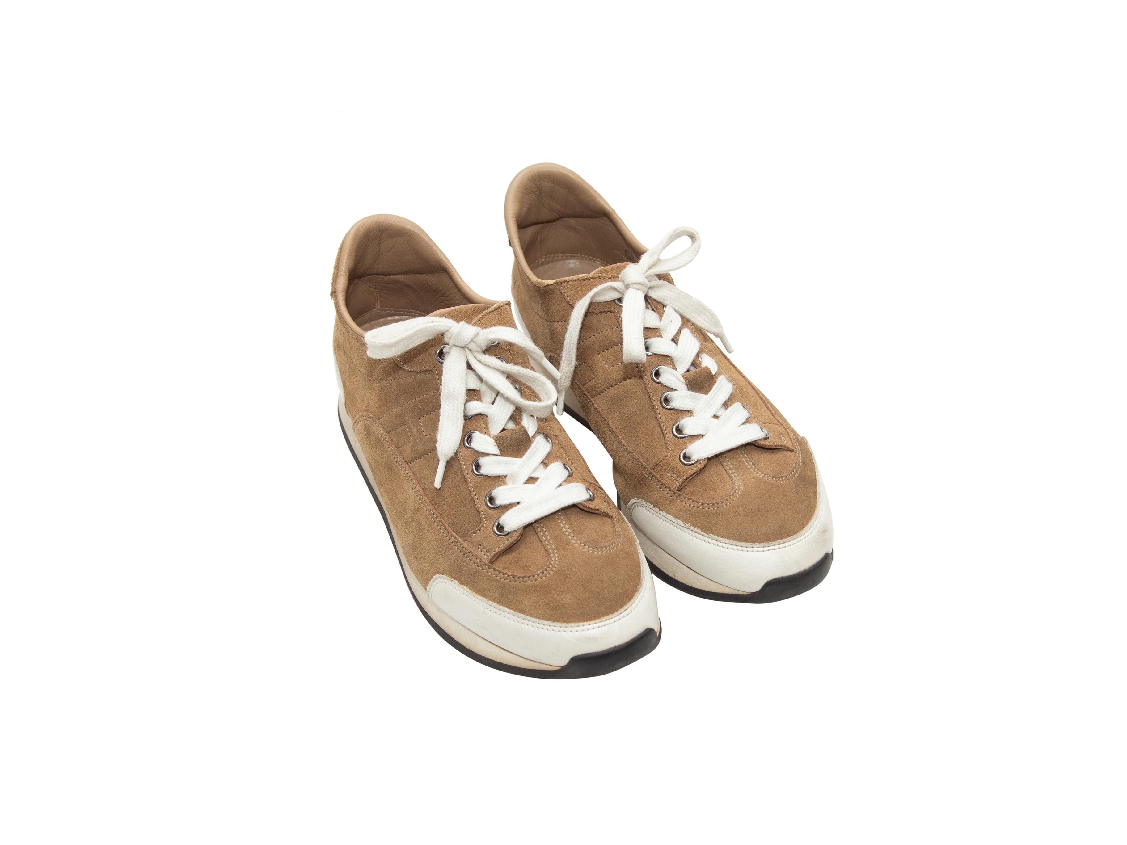 Product details: Brown suede low-top Goal sneakers by Hermes. White trim throughout. Lace-up tie closures at tops. Designer size 38.5. 0.75
