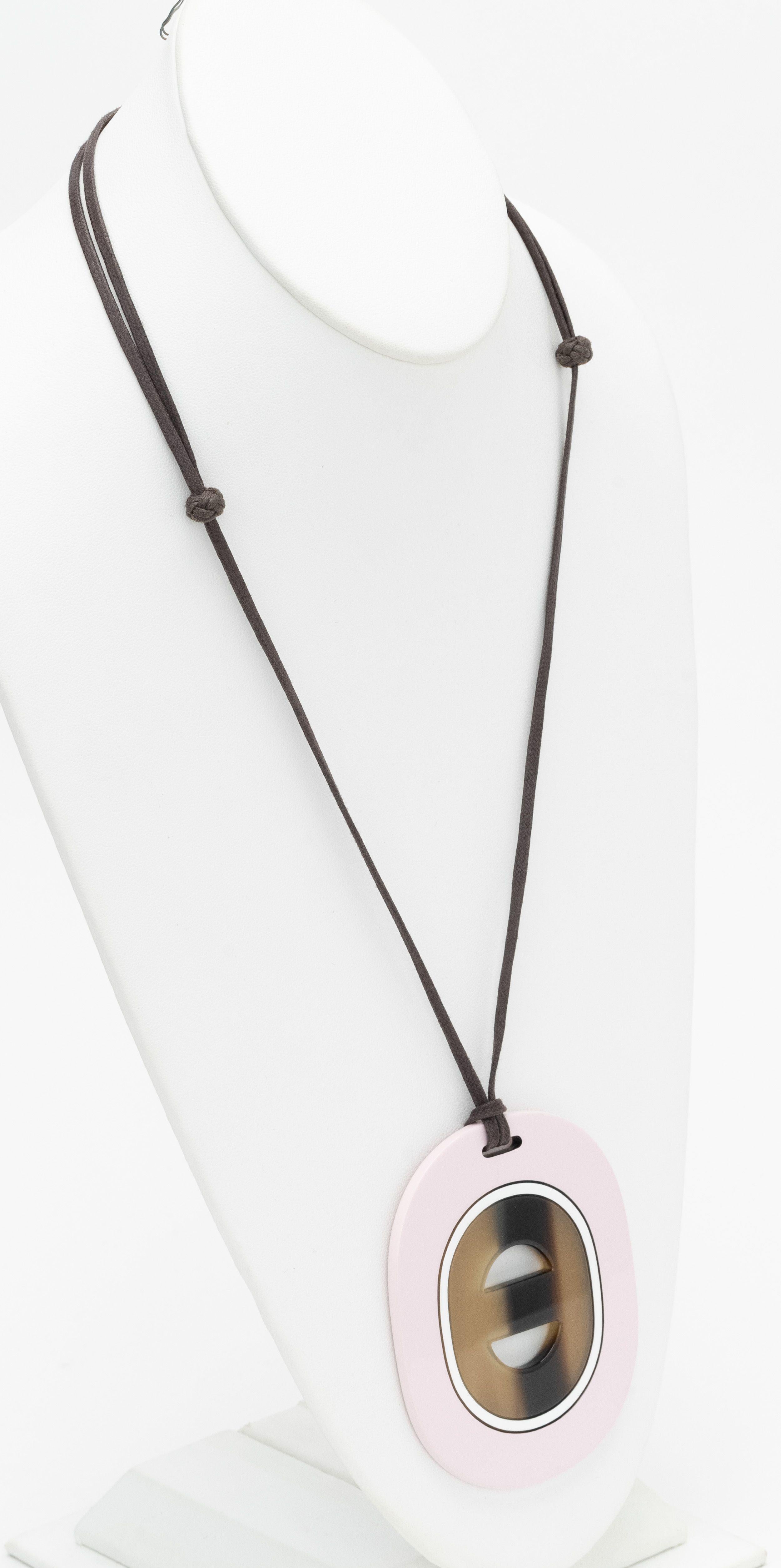 Collier Hermès Buffalo en rose. Au centre de l'ovale se trouve de la corne encadrée par de la corne laquée rose. Le pendentif mesure 3,25 x 2,75
