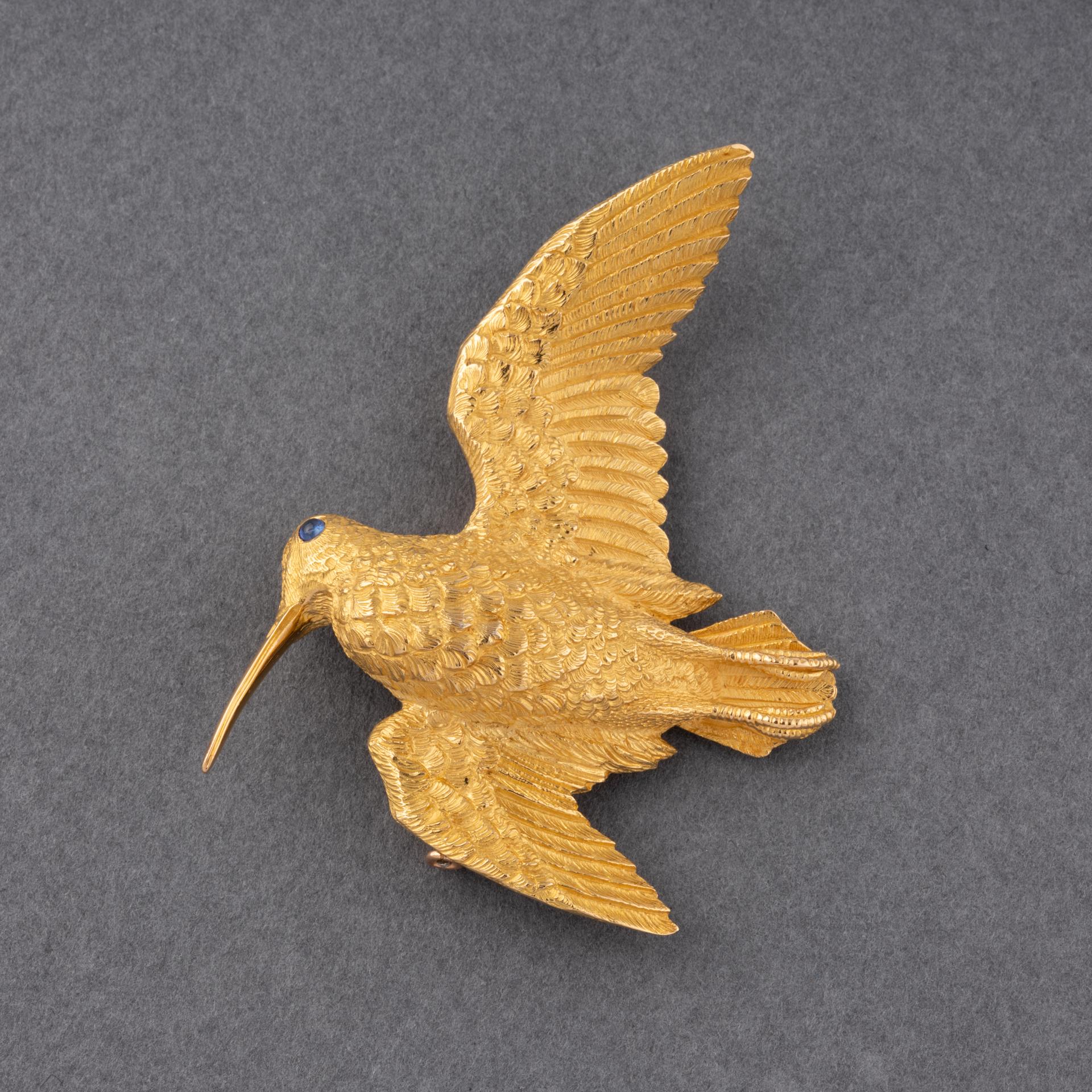 A very lovely vintage brooch, signed Hermès with the hallmark of George Lenfant.
Signed Hermès Paris 42321.
Made in yellow gold 18K and set set with a blue stone for the eye. Hallmarks for gold 18: the eagle head.
Dimensions: 58*47mm.
Weight: 24.90